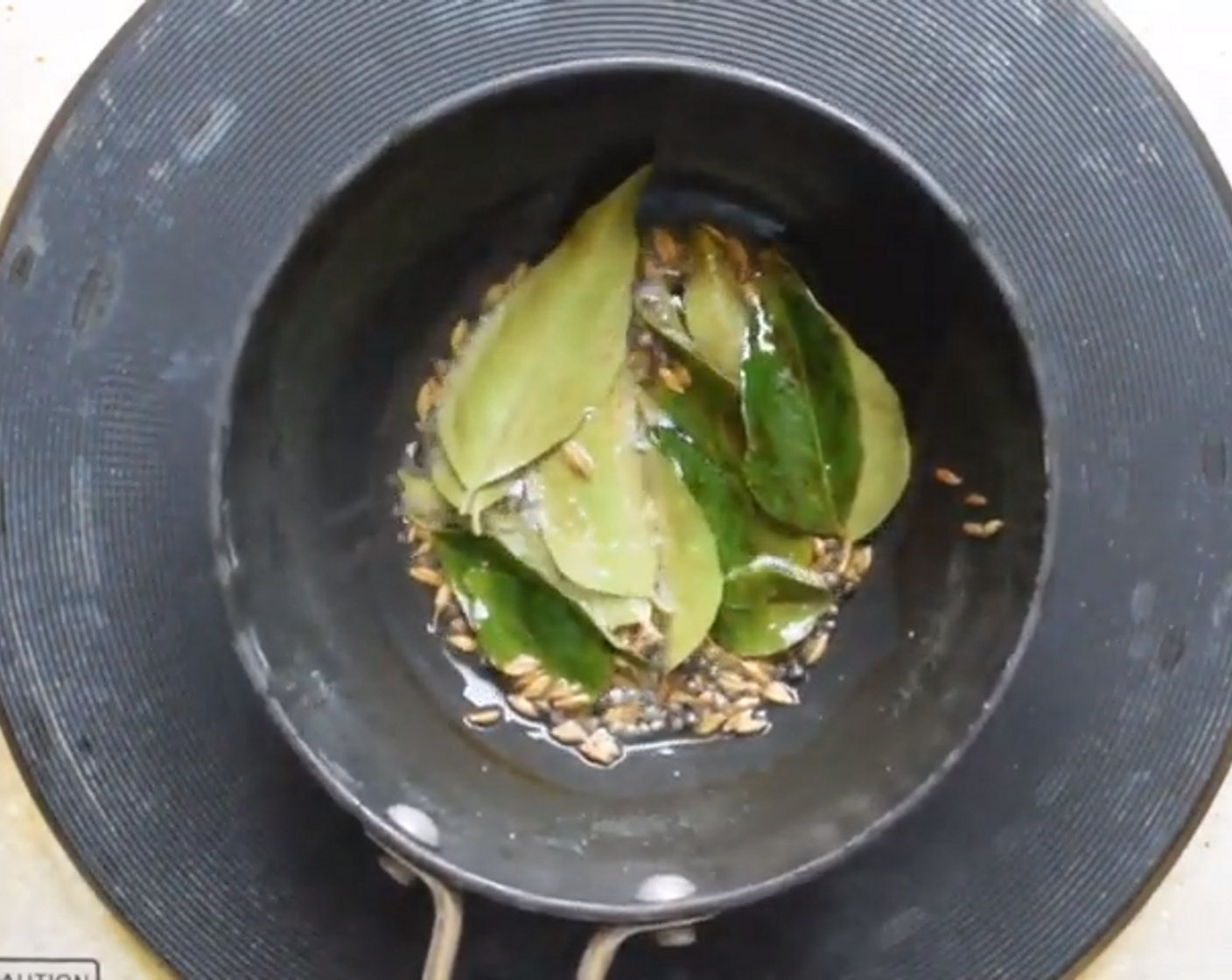 step 5 In a tadka pan, temper Mustard Seeds (1/2 Tbsp), Cumin Seeds (1/2 Tbsp), and Curry Leaves (5). Fry in Oil (1 tsp) for 30 seconds and then pour this over the batter. Mix it all together.