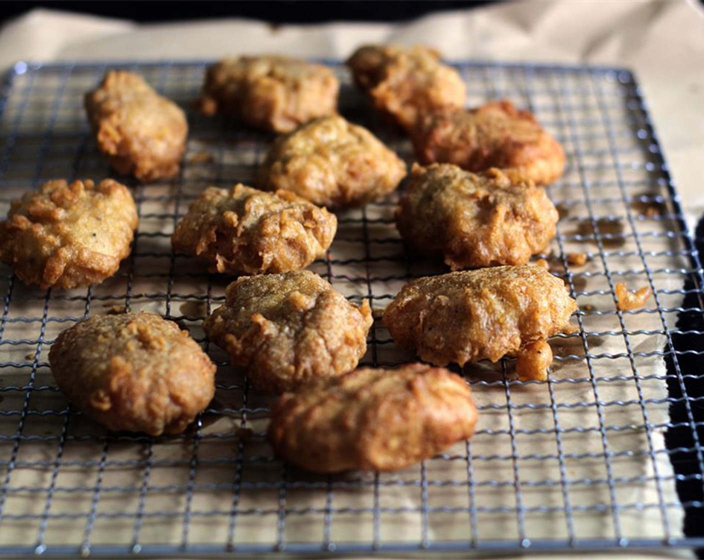 step 14 Drain the nuggets over a cooling-rack. Remove small pieces of batter from the oil with a slotted spoon in between each batch.