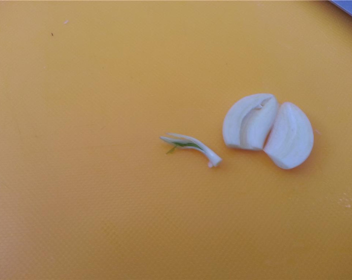 step 5 Peel the Garlic (1 clove) and slice in half. Crush the garlic with the side of your knife. Before crushing I like to remove the green germ just out of habit. Feel free to leave it if you like.