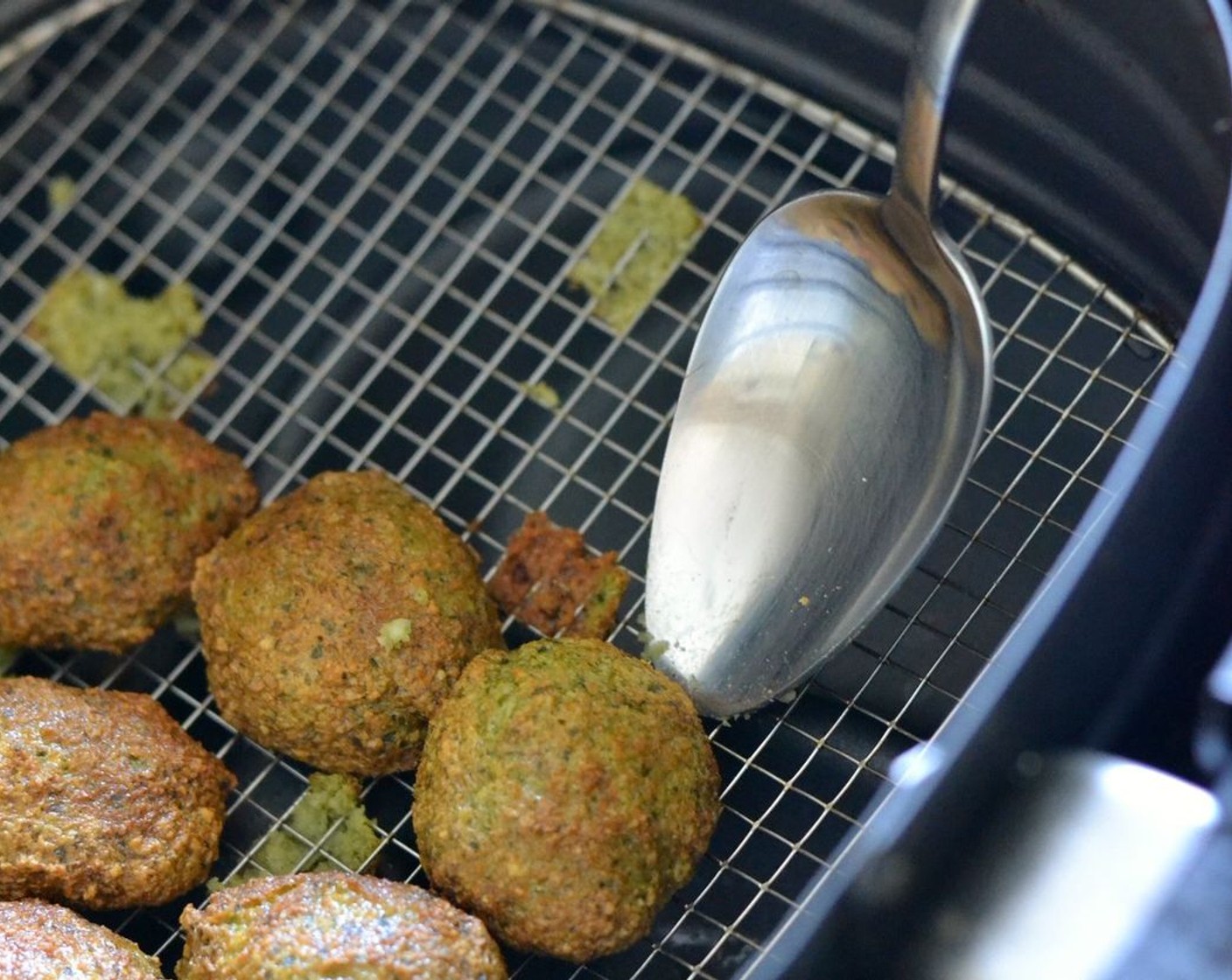 step 6 Use a spoon to gently coax the falafel balls out of the air fryer basket. They might leave a tiny piece of their bottom parts behind but that’s totally okay.