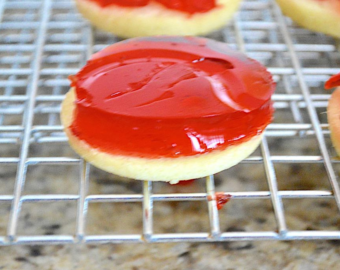 step 7 Take the hardened jello and use a 2-inch round cutter to cut 10 discs out of it. Place one on top of each little cake.