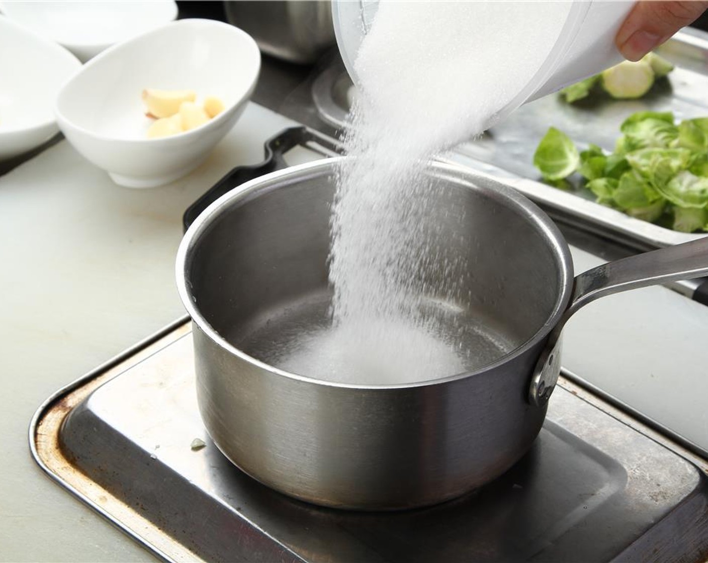 step 16 For the cranberry gastrique, begin by moistening the Granulated Sugar (1 cup) lightly with water in a medium saucepan, and place over medium heat.