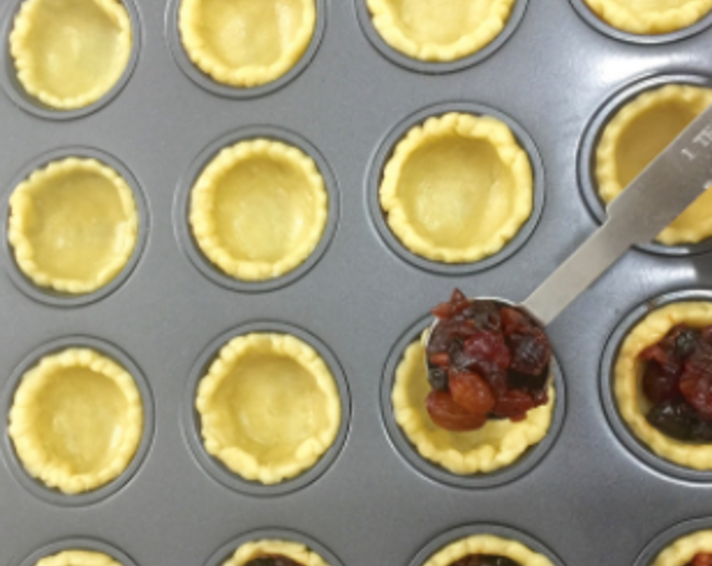 step 20 Then top with a heaping teaspoon of fruit mince in each of the cut pastry cup in the muffin pan.