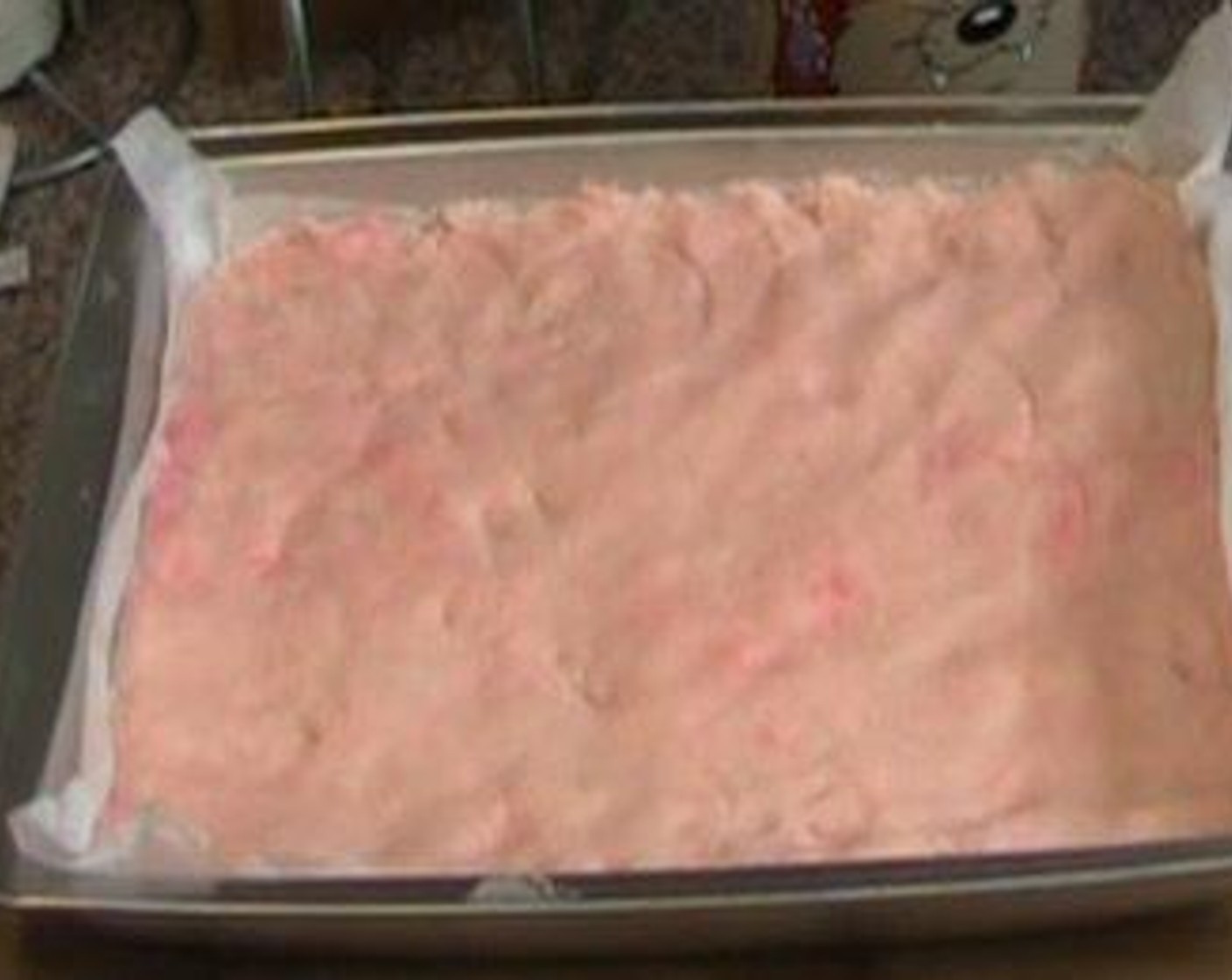 step 2 Transfer dough to a baking dish lined with parchment paper. Using your hands, press the dough down until it covers the dish evenly.