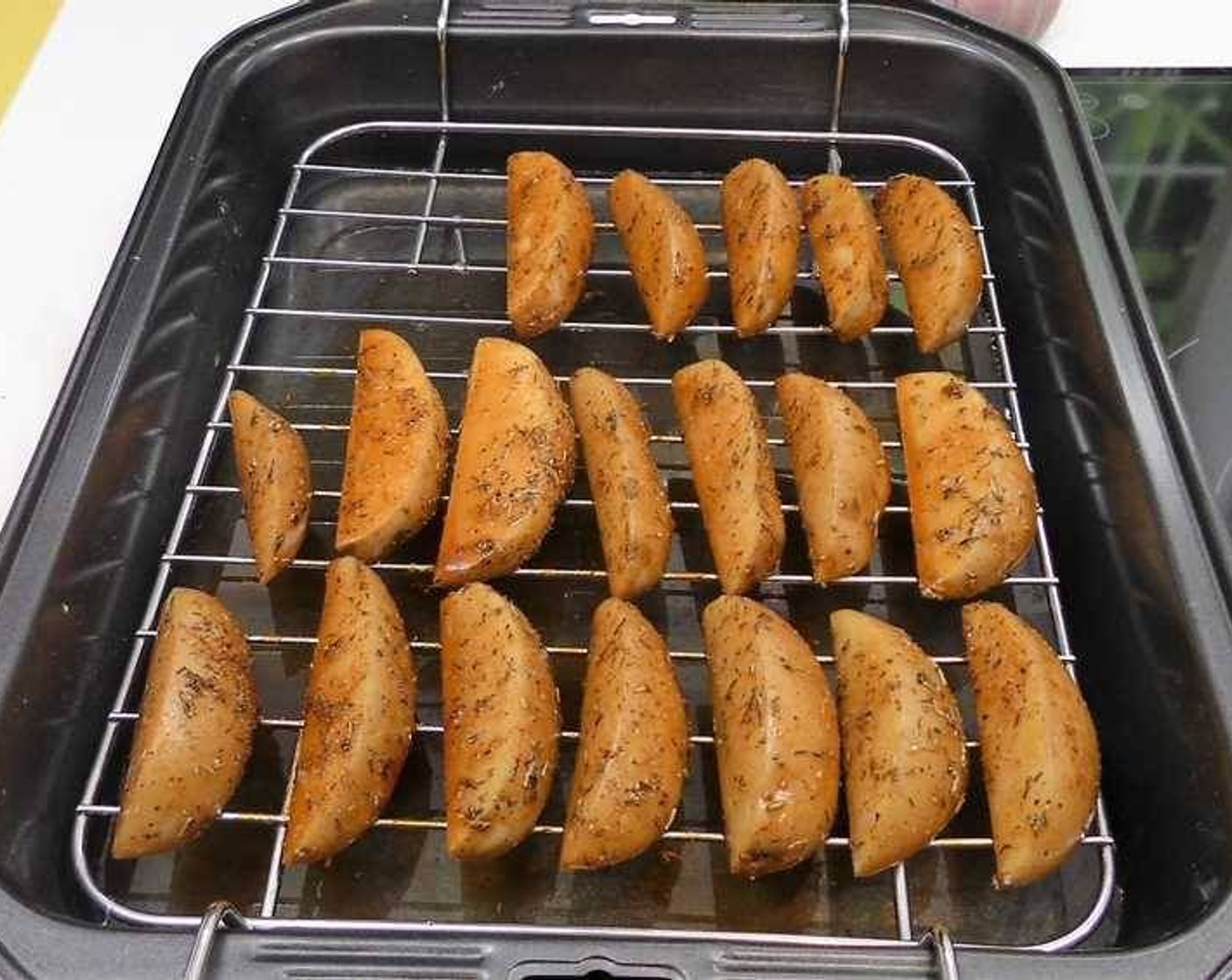 step 4 Once the wedges are covered in oil and spices, remove them and place on a baking rack with tray. Add a little bit of water on the bottom of the pan.