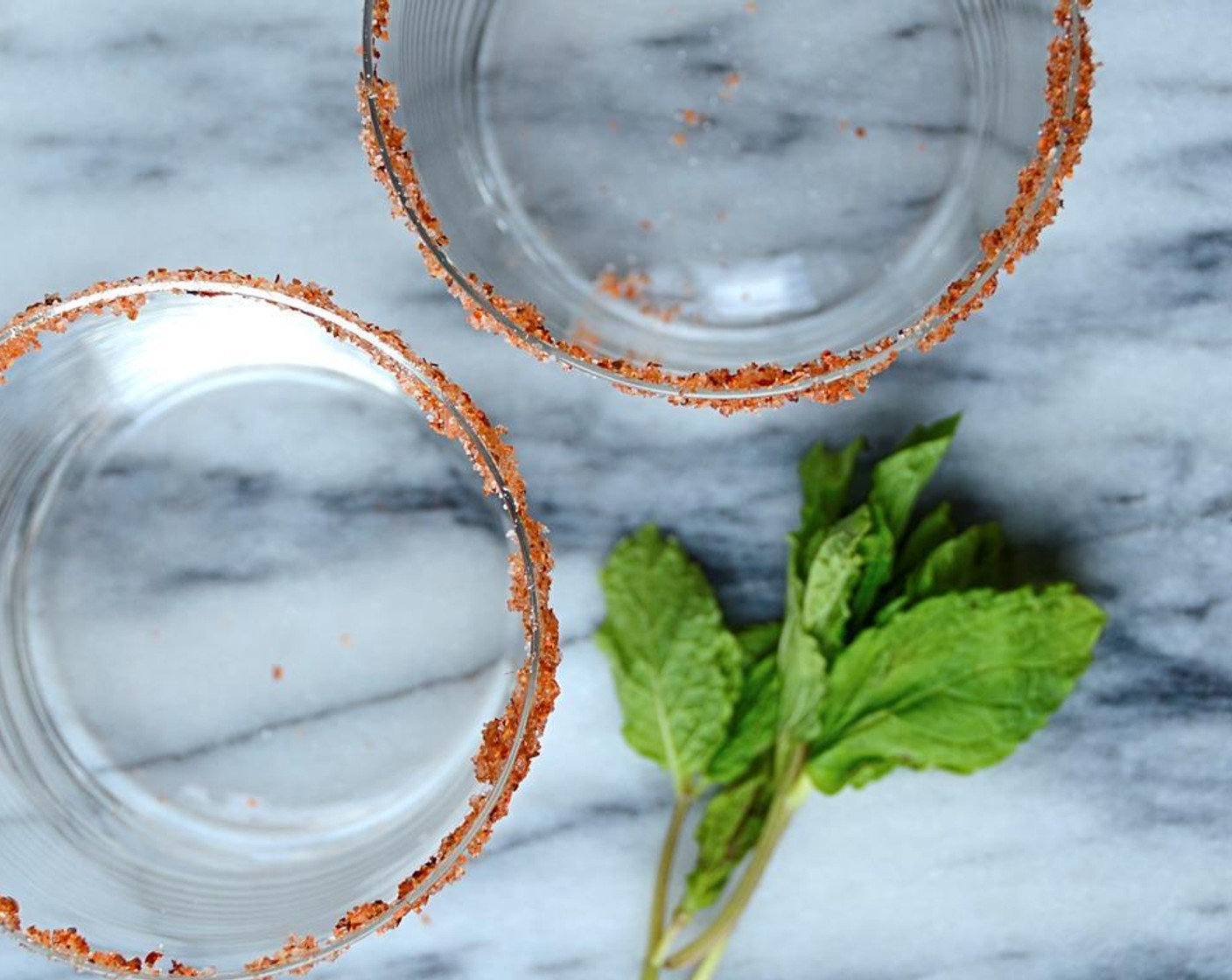 step 2 Dip the rim of each glass into the water and then into the tajin mixture. Set aside.