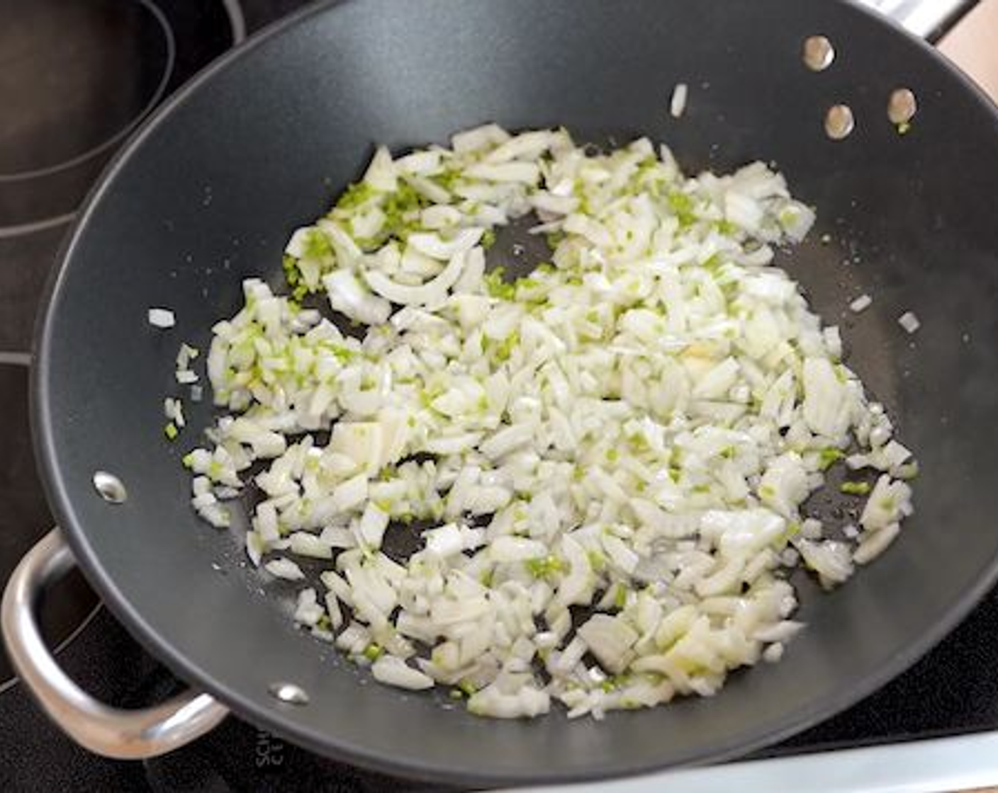 step 8 In a large pan add Sunflower Oil (1 1/2 Tbsp), White Onion (1), diced cilantro stems and season with Salt (1 tsp). Stir and cook for about 4 minutes.