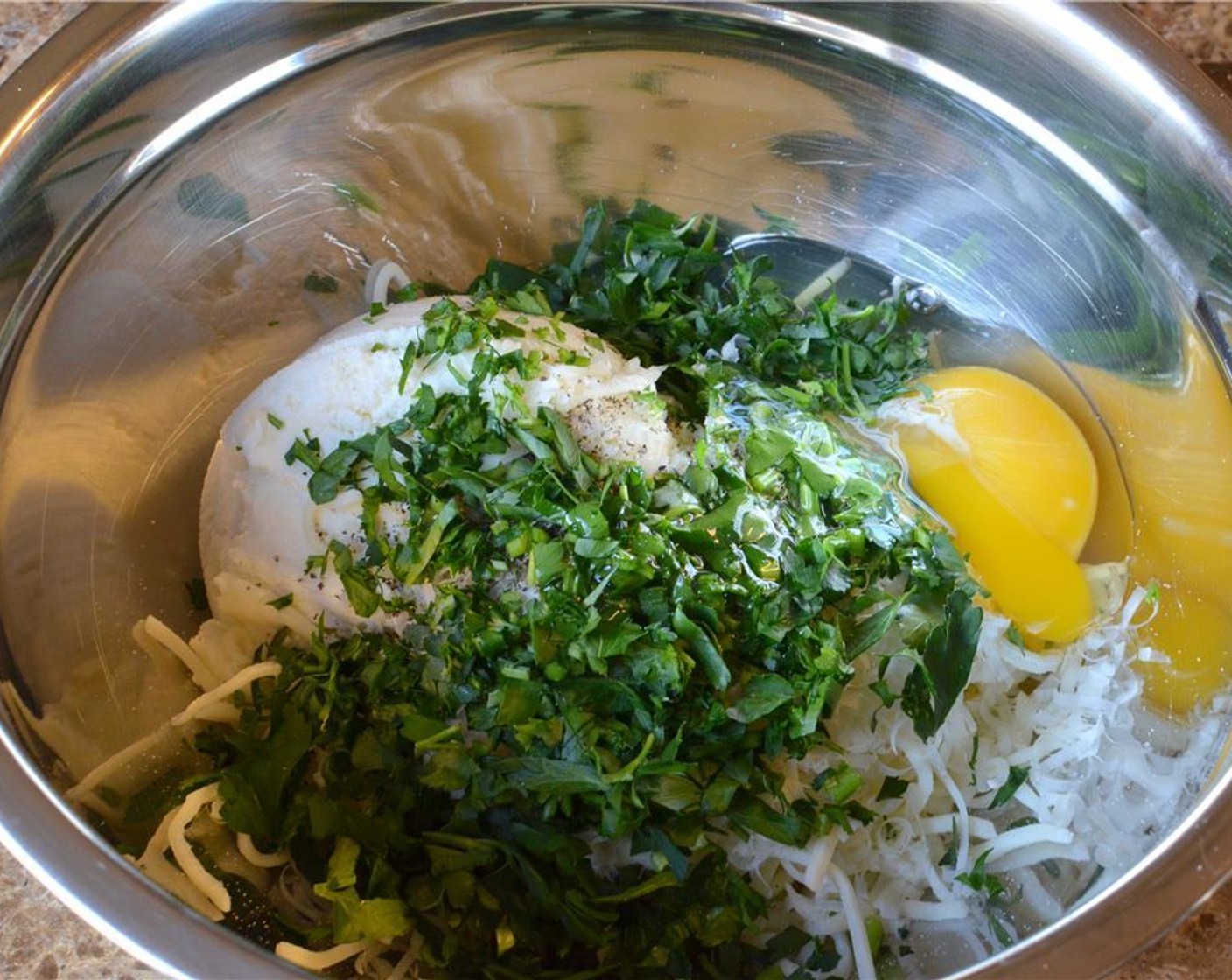 step 8 In a mixing bowl, add the Ricotta Cheese (1 3/4 cups), Mozzarella Cheese (1/2 cup), Parmesan Cheese (1/2 cup), one part of the fresh Italian Flat-Leaf Parsley (1 handful), Farmhouse Eggs® Large Brown Egg (1), Salt (to taste) and Ground Black Pepper (to taste).