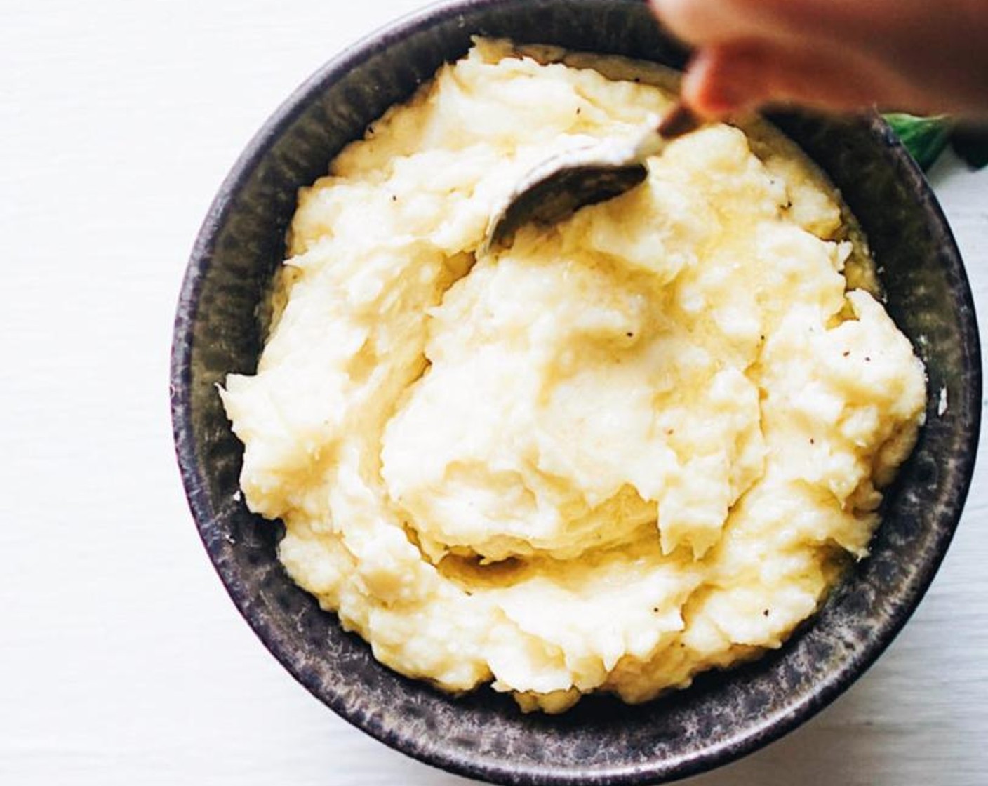 step 4 Heat the cream until hot (either stove top in a small sauce pan or microwave), carefully remove the garlic cloves, then stir into the mashed potatoes. Once creamy, add in as much or as little Butter (2 Tbsp) as preferred then season with Salt (to taste) and Ground Black Pepper (to taste).