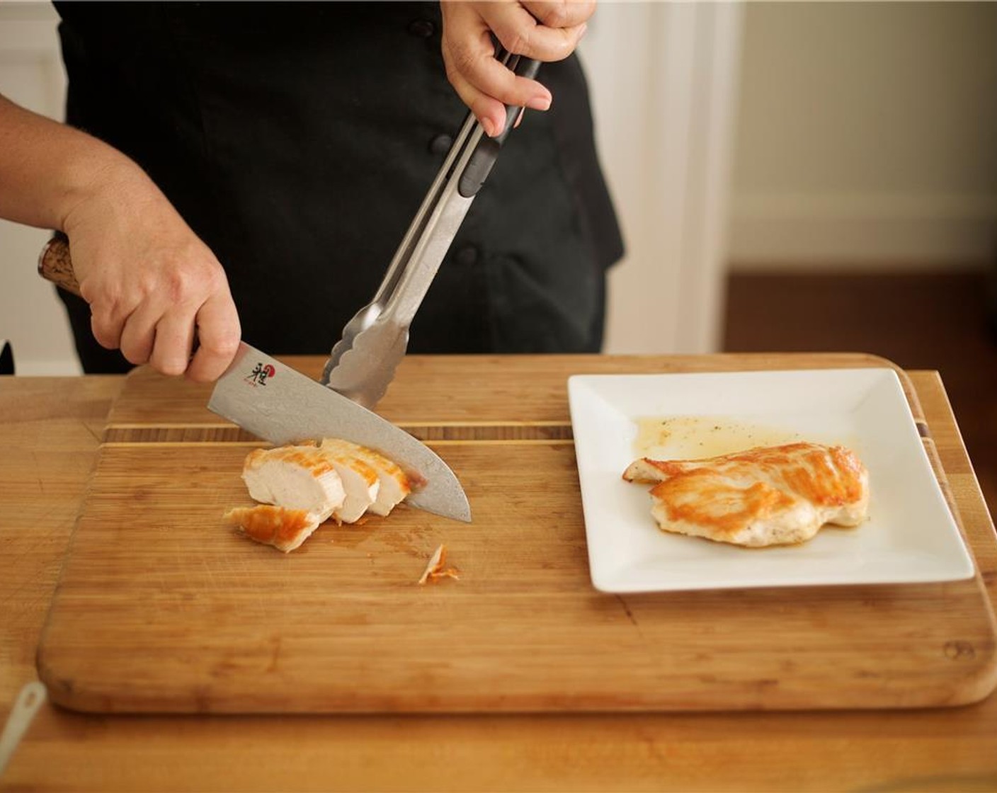step 10 Slice the chicken ¼" thick at a 45-degree angle. This is called a “bias” cut. Transfer one sliced chicken breast to each plate and fan the chicken across bottom rim of plate. Drizzle chicken drippings from plate over sliced chicken.