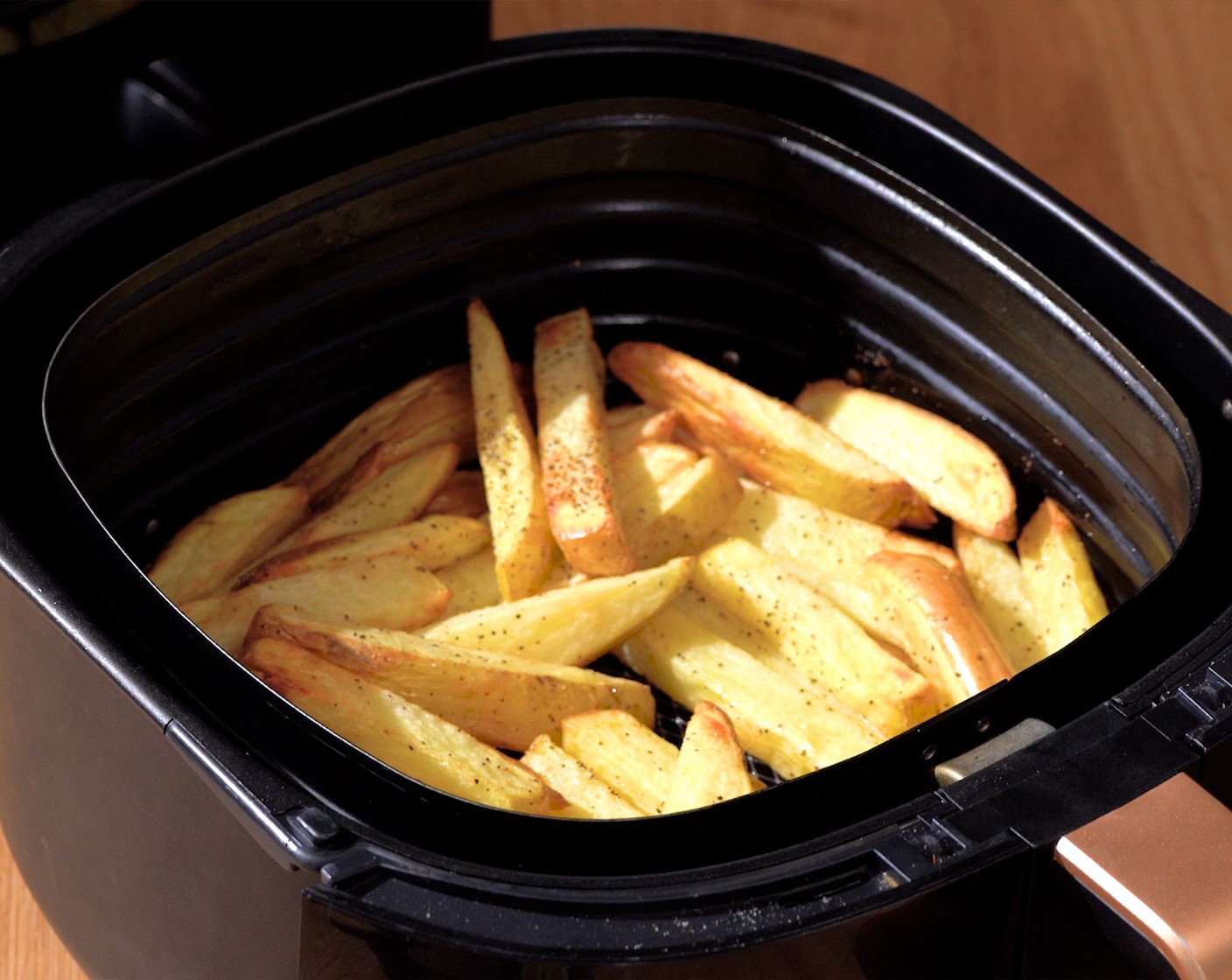 step 6 After 12 minutes, pull out the basket, sprinkle with seasoning, and toss evenly with the rest of the Cooking Oil (2 Tbsp). Continue cooking for 10-12 minutes more, depending on the thickness of the fries, or until golden brown.