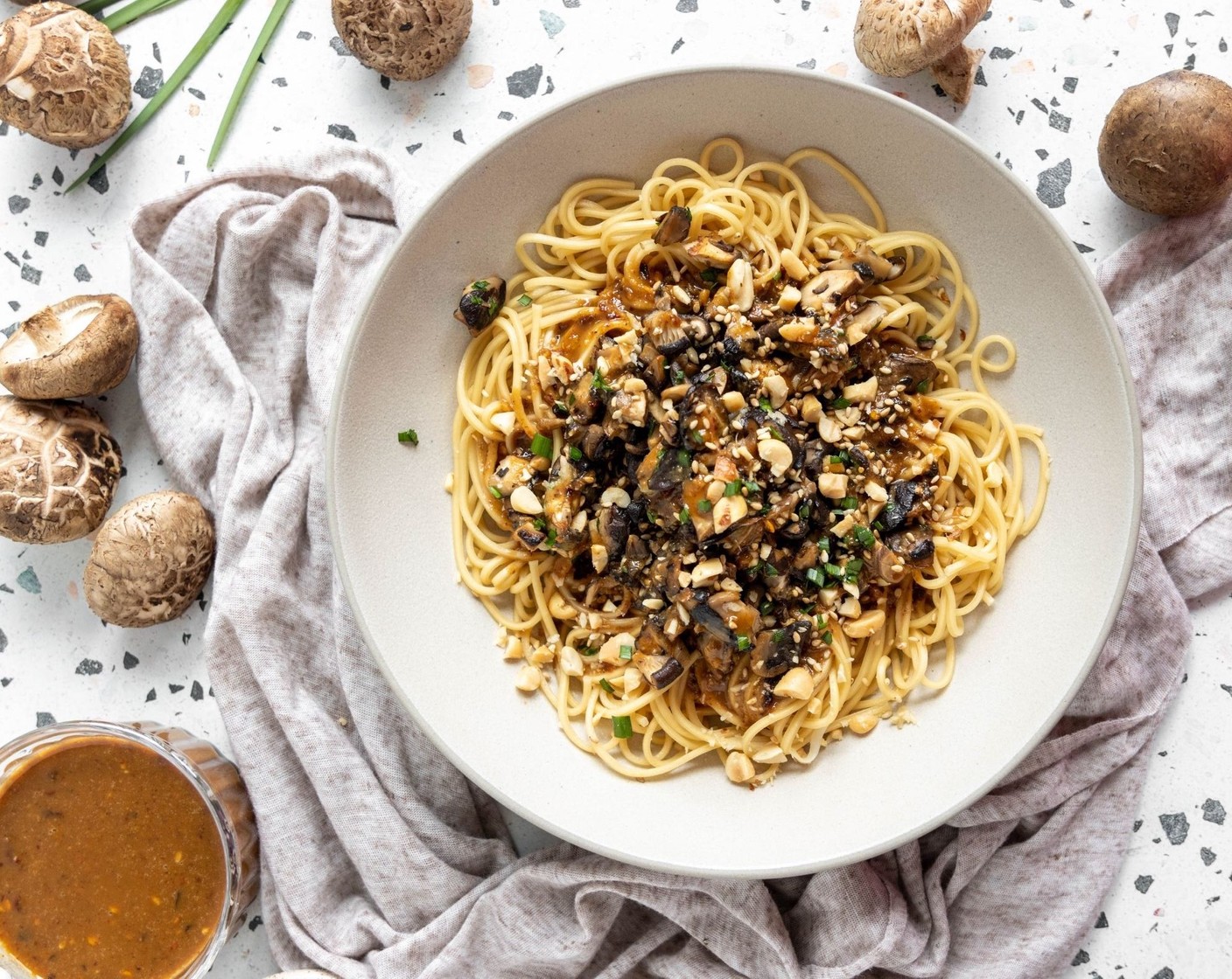 step 7 Divide the noodles into your bowls and top with sauce and mushrooms mixture. Garnish with Dry Roasted Peanuts (1 cup) and Roasted White Sesame Seeds (to taste) and serve. You can enjoy these noodles warm or cold!
