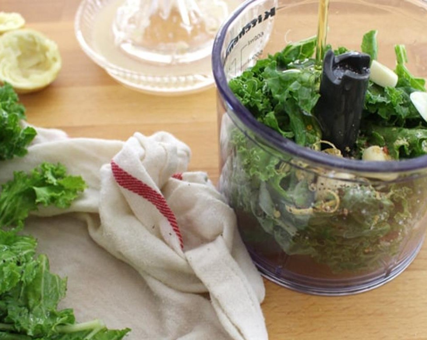 step 1 Place the Kale (1 bunch), Garlic (2 cloves), Olive Oil (4 Tbsp), Salt (to taste), Parmesan Cheese (4 Tbsp), Cayenne Pepper (1 dash), Lemon (1), and Fresh Ginger (1 pinch) in a blending apparatus. Blend for at least 60 seconds, stopping and scraping down the sides if needed.