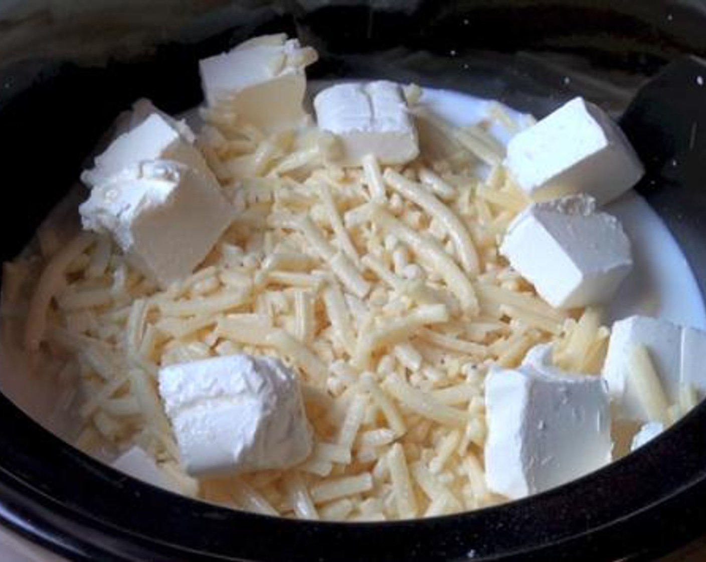 step 1 Into a slow cooker, add the Elbow Macaroni (1.1 lb), Cheddar Cheese (3 cups), Cream Cheese (1 cup), Milk (1 cup), and Evaporated Milk (1 1/2 cups). Season with Salt (to taste) and Ground Black Pepper (to taste) and allow it to simmer for 2 and half hours on the low setting.
