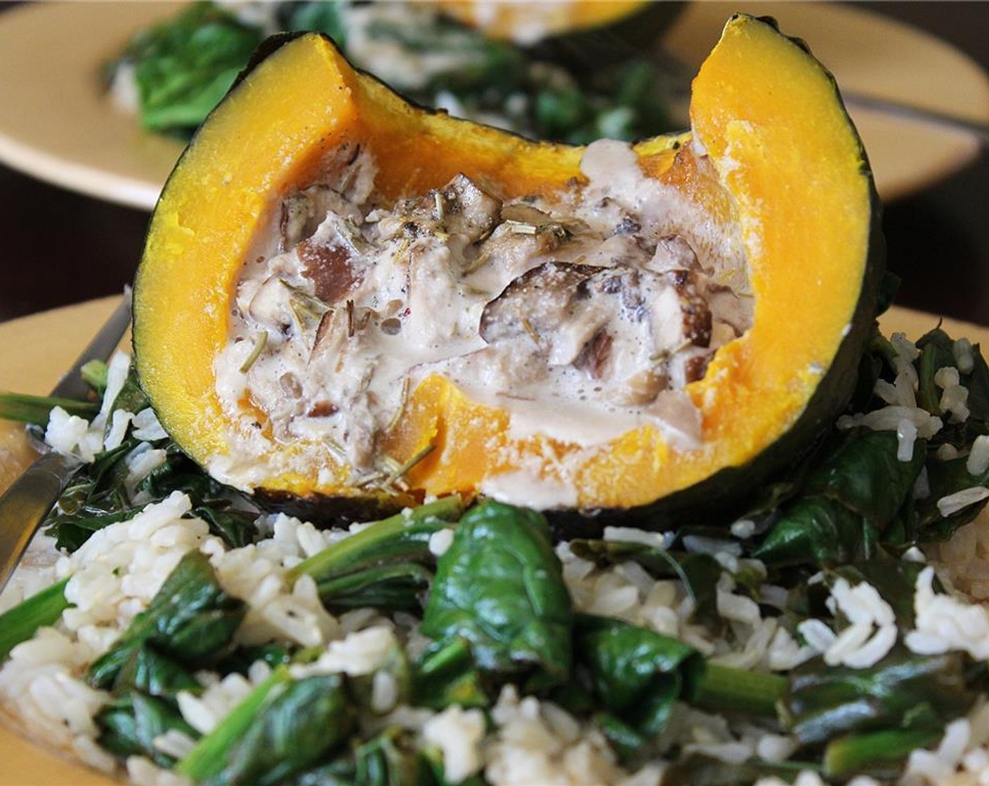 step 10 Place the rice and spinach on the plates and put the pumpkin on top of one of the servings of rice. Cut the pumpkin down the middle and quickly transfer the other half with its cream to the other plate. Dig in.