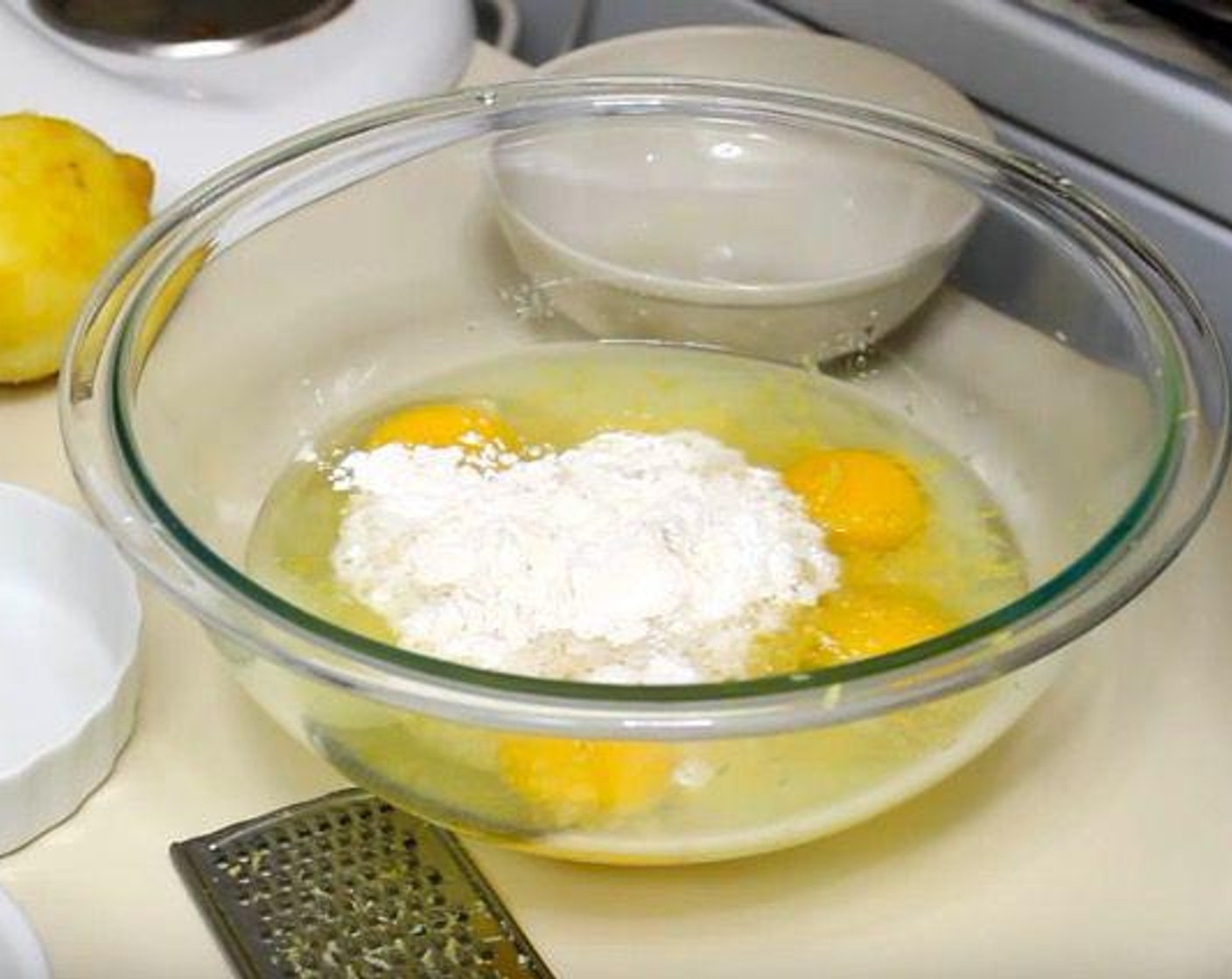 step 4 In a mixing bowl, add Eggs (3), Granulated Sugar (1 cup), zest and juice from Lemons (2 1/2 cups), Baking Powder (1/2 tsp), and All-Purpose Flour (1/2 cup). Mix until combined.