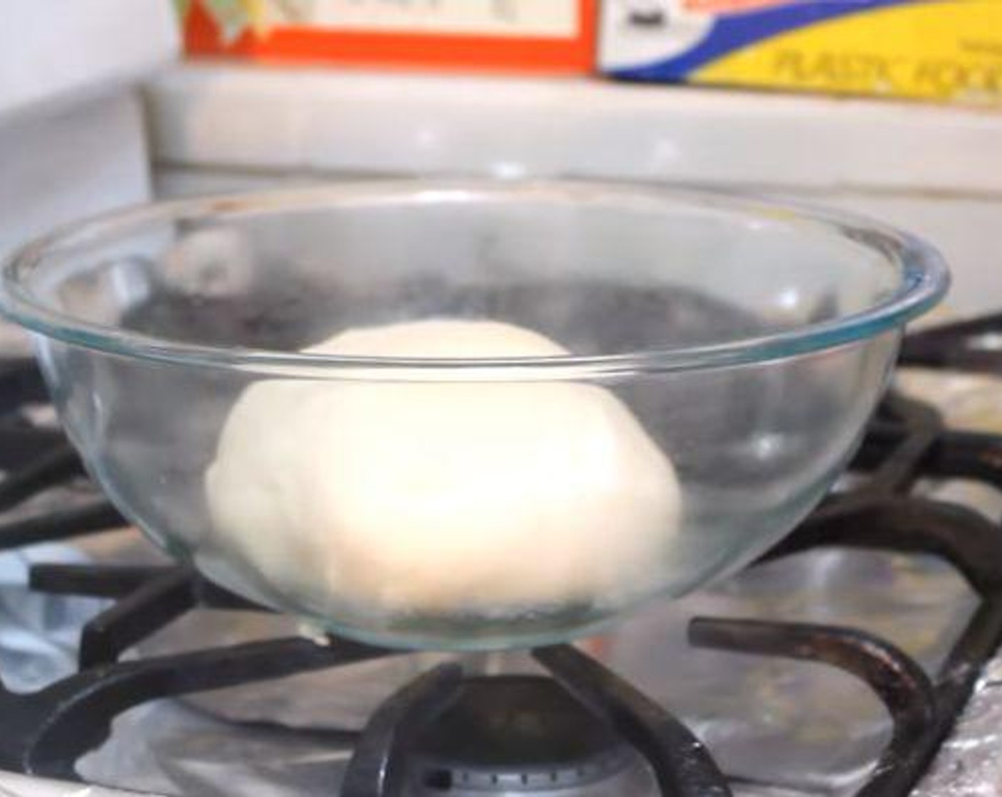 step 3 In the bowl of a stand mixer, add the dry and wet ingredients. Knead the dough until nice and smooth. Grease a bowl and add the ball of dough. Spray the top of the ball as well. Cover with plastic wrap and let sit in a warm place for 1 1/2 hours