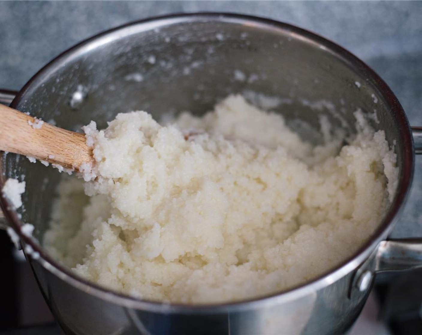 step 4 Remove the lid, and using a large wooden or metal fork, stir the maize until it forms large clumps.