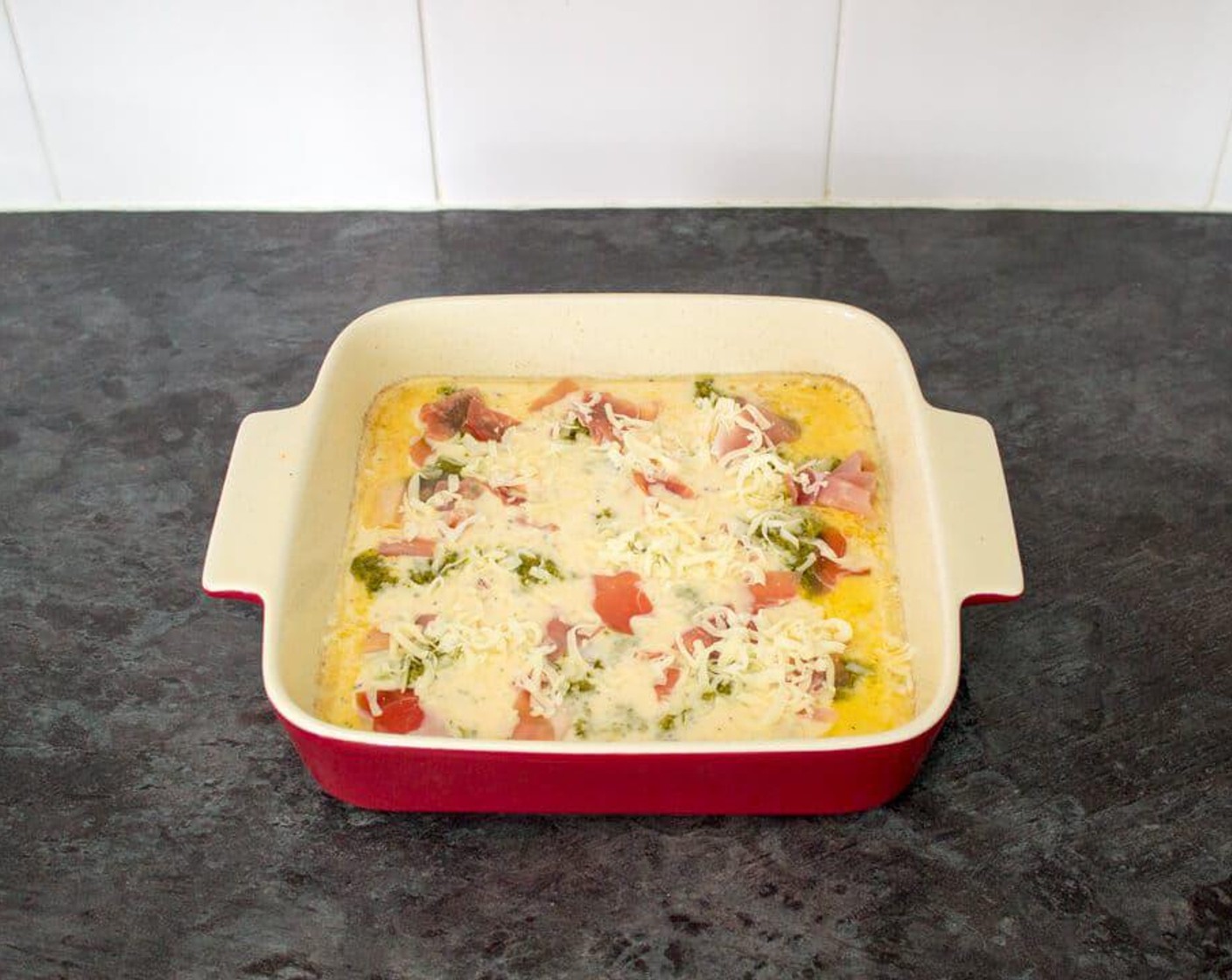 step 6 Scatter over Basil Pesto (1/3 cup), Mozzarella Cheese (1/2 cup) and Prosciutto (2 oz) then put straight back into the hot oven. Bake for 20 minutes until risen, golden & beautiful.