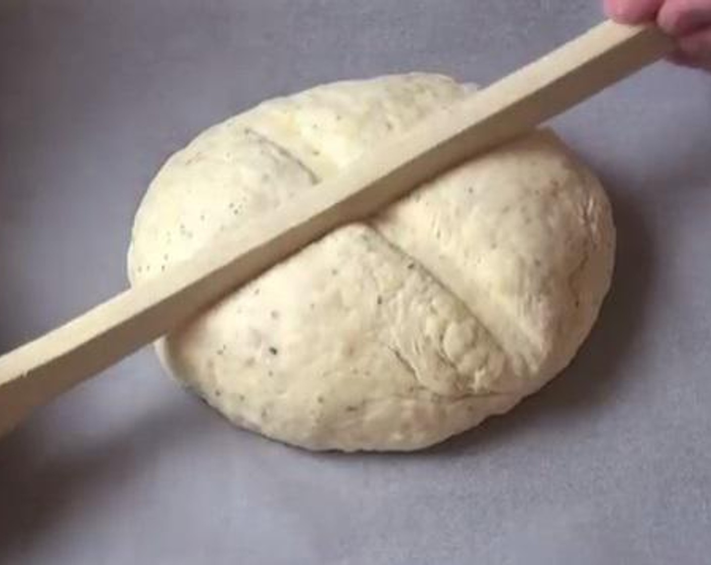 step 6 Shape the dough into a round spherical shape. Using the handle of a spoon, make some indentations across the top of the dough. Brush a little bit of milk over the surface of the bread. Bake inside a preheated oven at 375 degrees F (190 degrees C) for about one half an hour.