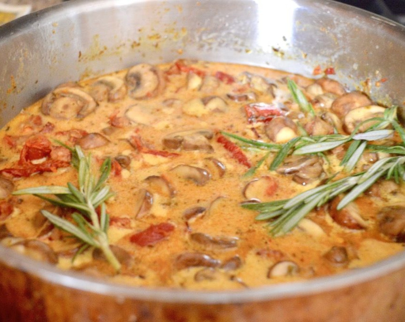 step 6 Let them start to soften and brown for 3-4 minutes, then add the Sun-Dried Tomatoes in Olive Oil (1 jar), and Garlic (2 cloves). Let them cook for just 30 seconds or so. While that cooks, season it all with the Ground Turmeric (1/4 tsp), Paprika (1/4 tsp), and Saffron Threads (1 pinch). Then pour in the Coconut Milk (2 cups) and add the bacon back to the pan, along with the Fresh Rosemary (3 sprigs).