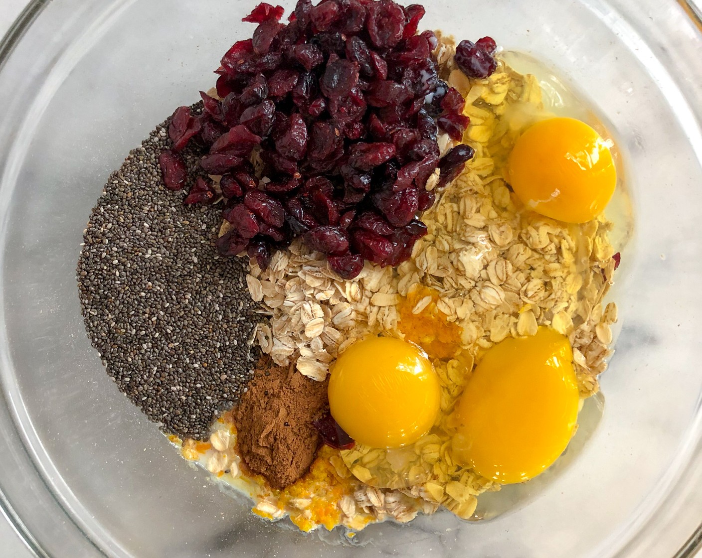 step 2 In a large bowl, mix together the Old Fashioned Rolled Oats (2 cups), Chia Seeds (1/4 cup), Pumpkin Pie Spice (1 Tbsp), Salt (1/2 tsp), Milk (3/4 cup), the juice and zest from the Orange (1), Farmhouse Eggs® Large Brown Eggs (3), Maple Syrup (2 Tbsp), and Dried Cranberries (1/2 cup) until combined.