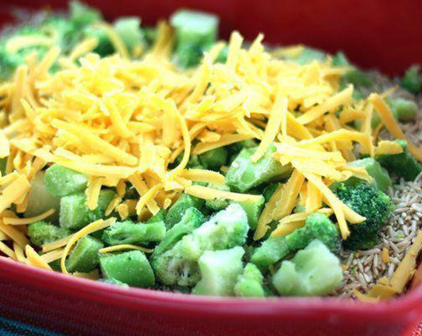 step 4 In a baking dish or casserole, stir together White Rice (1 cup), Frozen Broccoli (1 cup), Cream of Mushroom Soup (10.5 fl oz), 1 cup of cheddar cheese, Water (1 3/4 cups), Ground Black Pepper (1/4 tsp), McCormick® Garlic Powder (1/4 tsp), and Salt (1/4 tsp). Combine well.