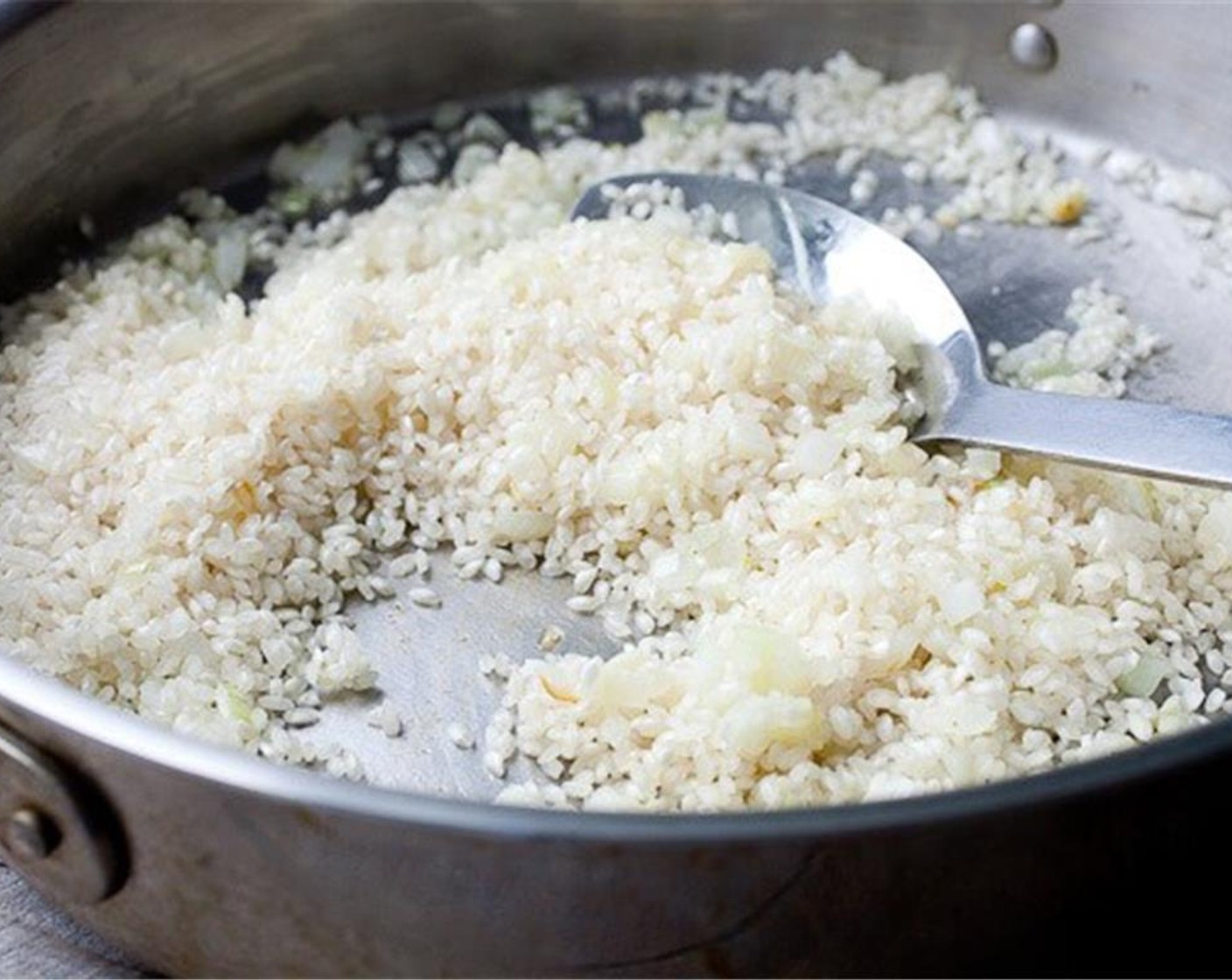 step 4 After the onions have softened, add the Arborio Rice (1 1/2 cups) and let it cook over medium heat for about 90 seconds. After the rice is dry cooked, add the Dry White Wine (1/2 cup) to the skillet and use the liquid to scrape up any bits. It’ll cook off quickly.