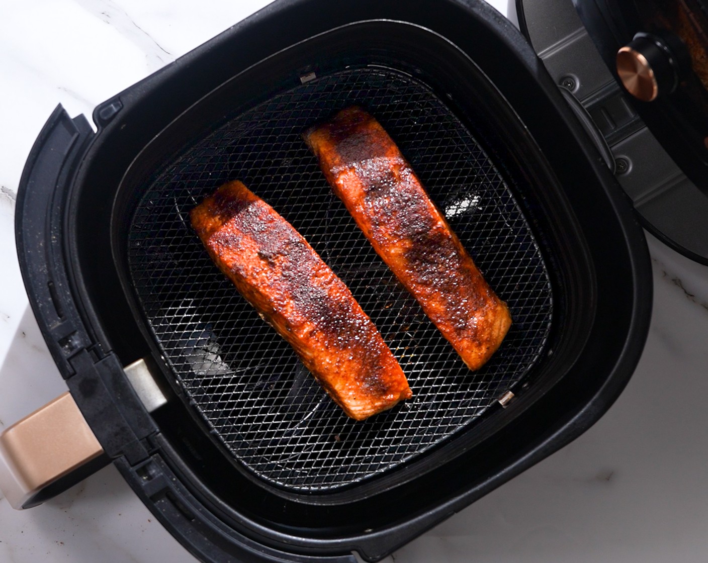 step 3 Grease the air-fryer basket with Nonstick Cooking Spray (as needed). Place salmon fillets into the basket. Air fry at 375 degrees F (190 degrees C) for 7-9 minutes, depending on the thickness of the salmon. Use a fork to poke the salmon, and if it flakes off easily, then your salmon is ready.