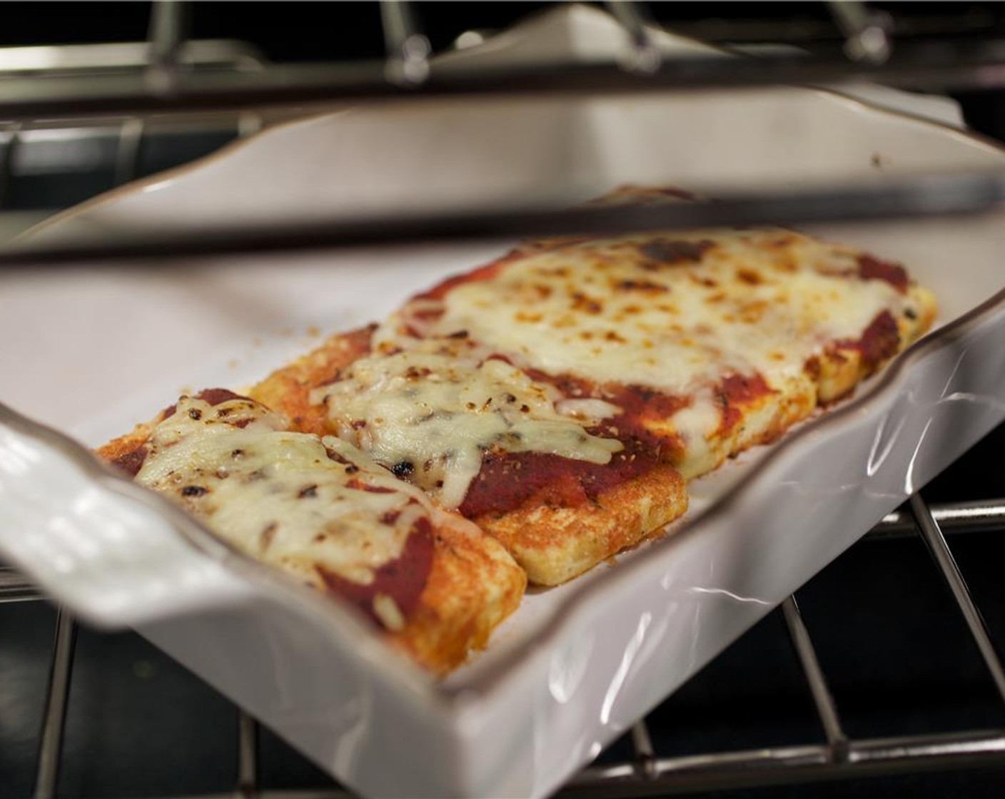 step 8 Arrange tofu slices in the pan and spoon remaining sauce over tofu. Top with half of the Mozzarella Cheese (1/4 cup) and one and a half tablespoons of parmesan cheese. Bake in the oven for 20 minutes until golden brown and heated through.