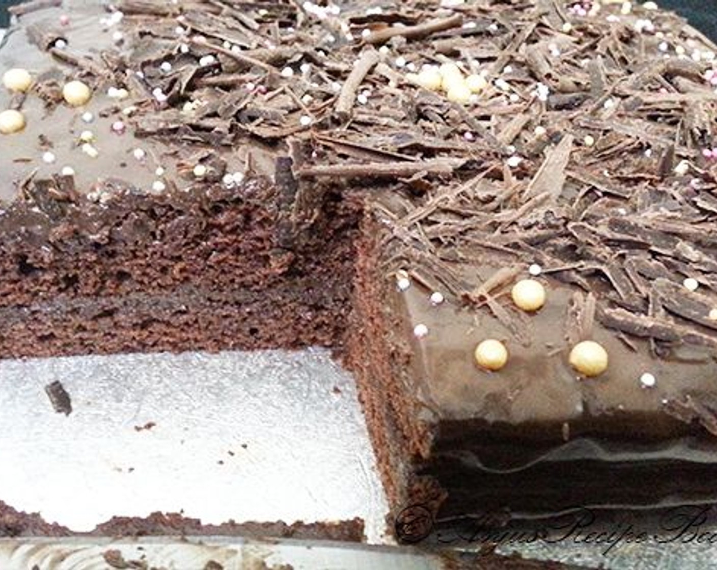 step 8 Decorate with some grated chocolate and some sugar balls. Keep in fridge for some time. The ganache will get a darker shade once cooled and set. Cut and serve cold.