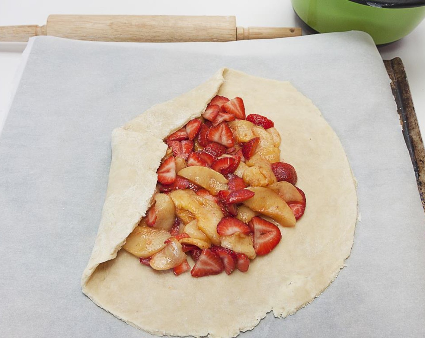 step 6 Line a pan with baking sheet. Roll dough into a 12 inch circle. Place circle on the sheet and spoon the fruit into the center of the dough leaving a 2 to 3 inch border. Gently fold the edges over the fruit, overlapping if necessary. Now pour all but 2 tbsp of juice on the fruit.
