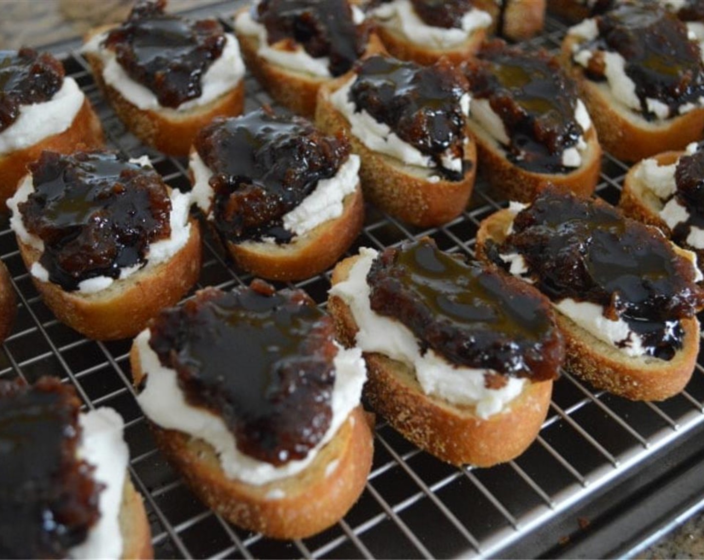 step 7 Dollop a half tablespoon of the Fig Butter (1 jar) onto each crostini on top of the goat cheese and spread it out a little.