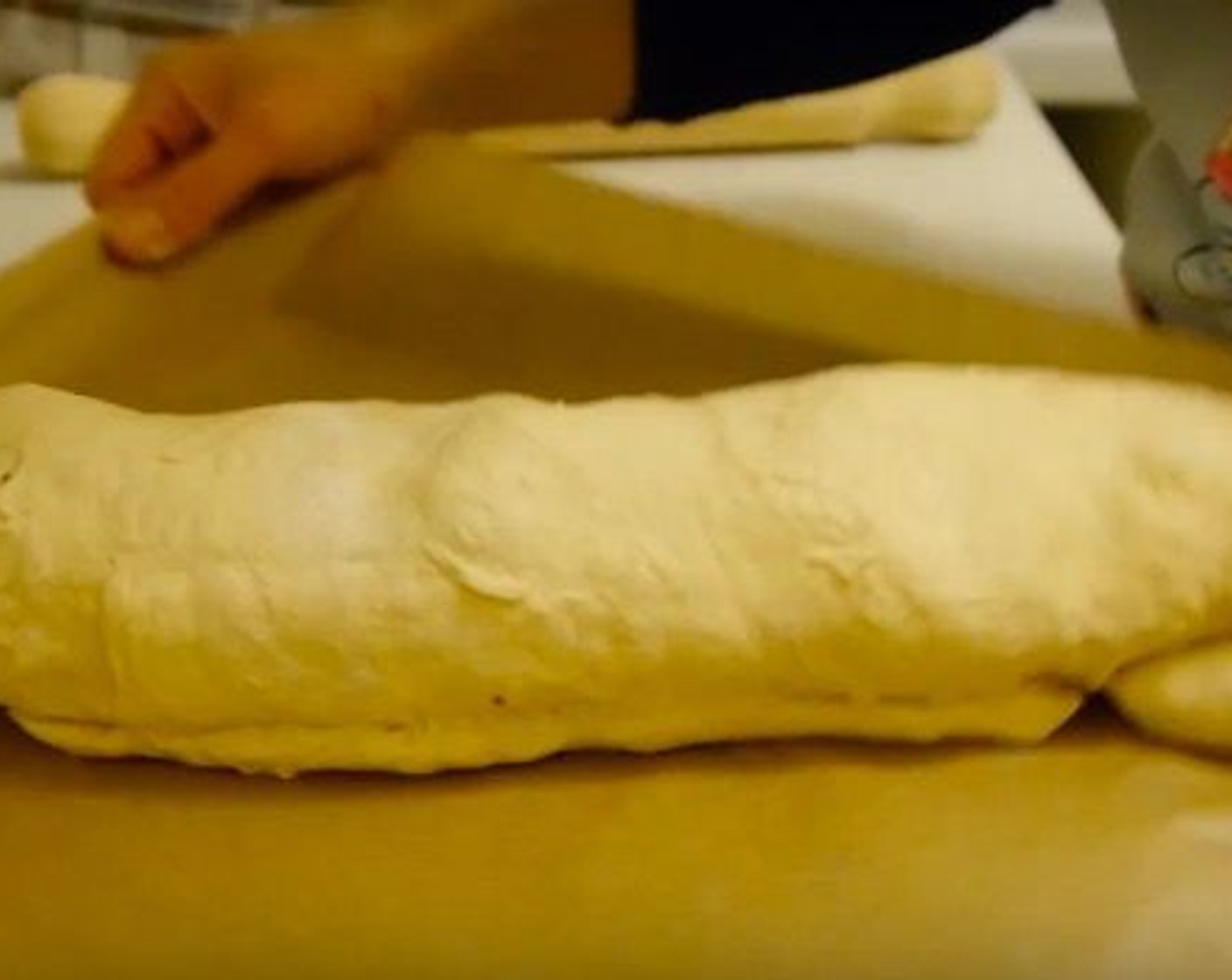 step 8 Once the dough is fully rolled and a "sausage" like bread has been created, move it to a baking tray lined with parchment paper.
