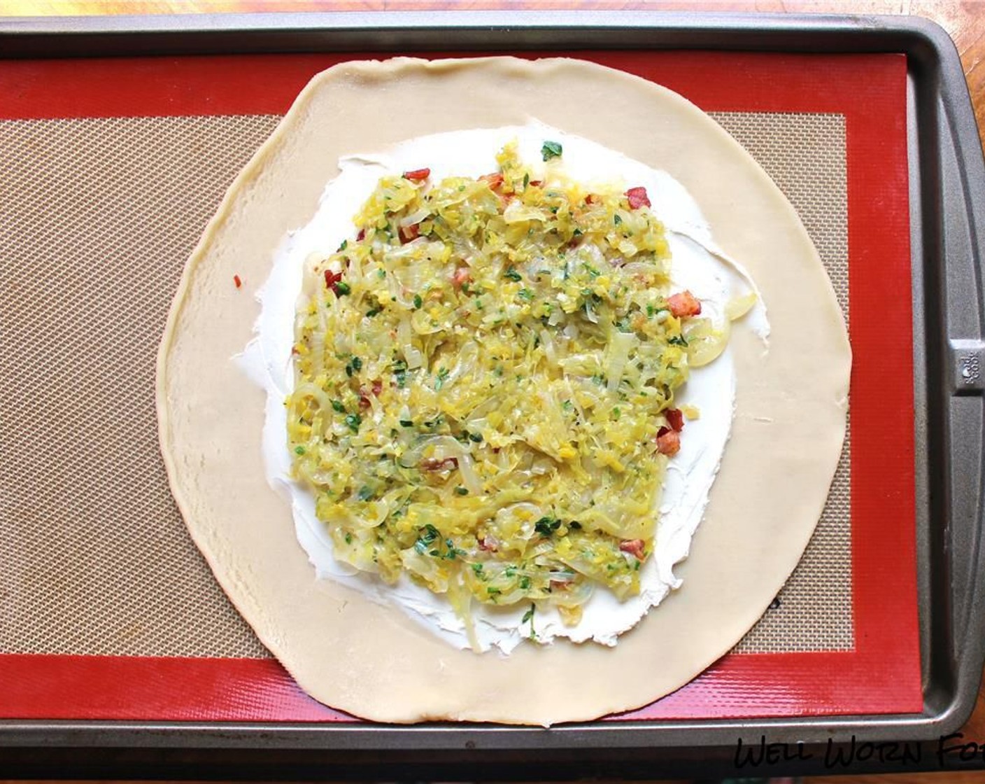 step 9 Spread the pancetta and leek/onion mixture on top of the cream cheese on each pie. Fold the overhanging dough over the leeks, pleating as you go.