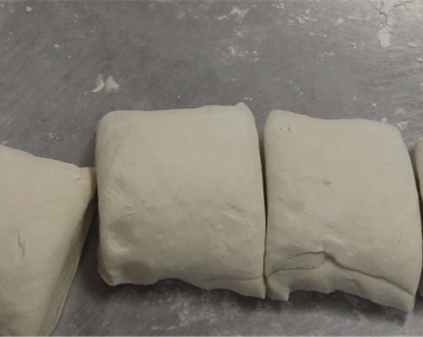 step 7 Cut the dough roll into four proportional sections.