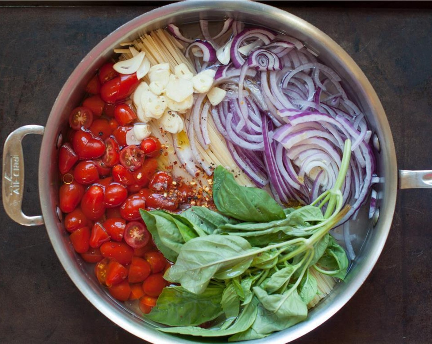 step 1 Put the Linguine (12 oz), Cherry Tomatoes (2 1/4 cups), Red Onion (1), Sea Salt (1/2 Tbsp), Ground Black Pepper (1/4 tsp), Garlic (4 cloves), Crushed Red Pepper Flakes (1/2 tsp), Extra-Virgin Olive Oil (2 Tbsp), and Fresh Basil (2 sprigs) in a large pot.