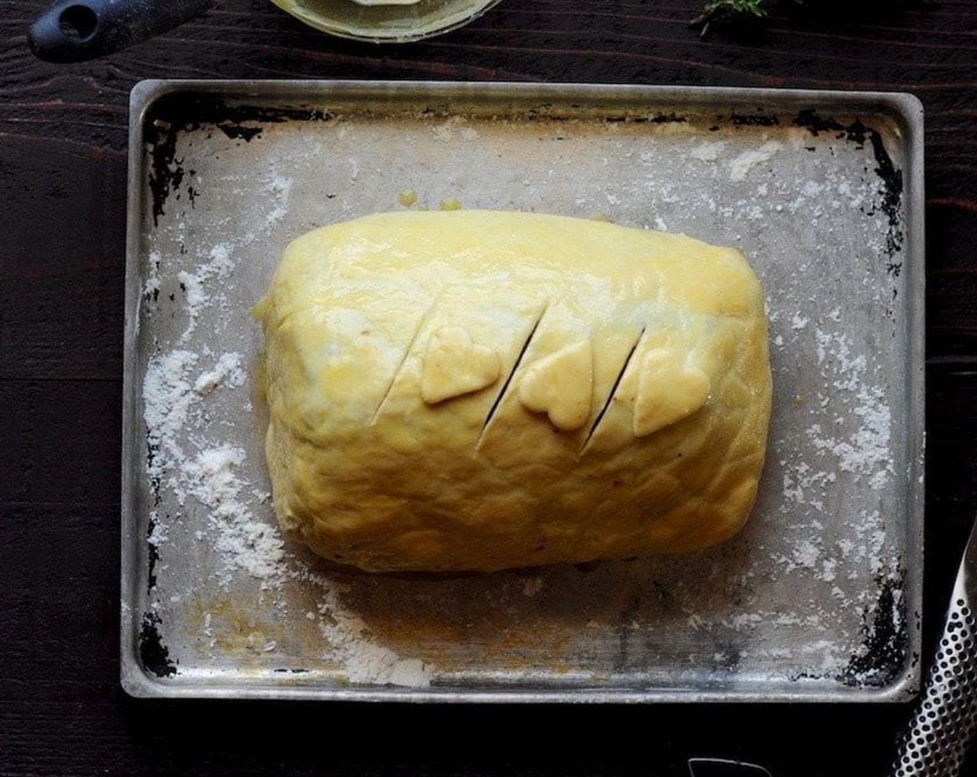 step 12 Dust a baking sheet lightly with flour. Place pastry-wrapped roast, seam-side down, on the baking sheet, and brush the top and sides with the egg. Cut 3-4 two-inch vents in the top of the pastry. Decorate with heart-shaped pastry cuttings if desired.