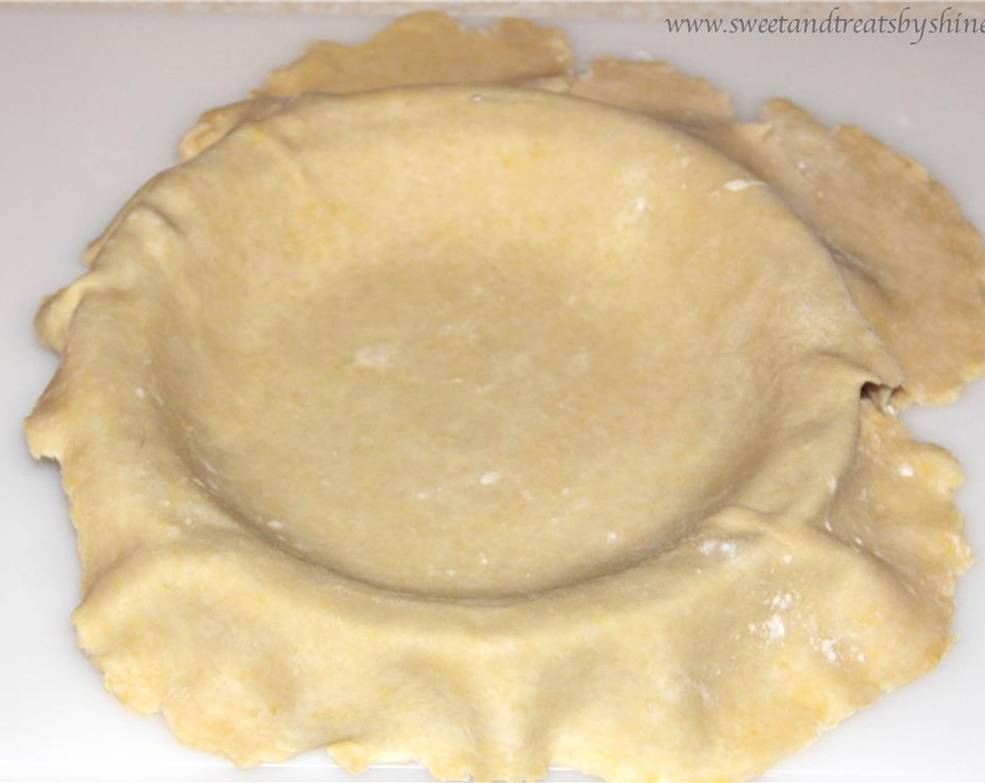 step 2 Roll out one half into a 10 to 11-inch circle on floured surface. Transfer onto the pie pan. Cut the extra dough hanging over the edges. Put it back into the fridge.