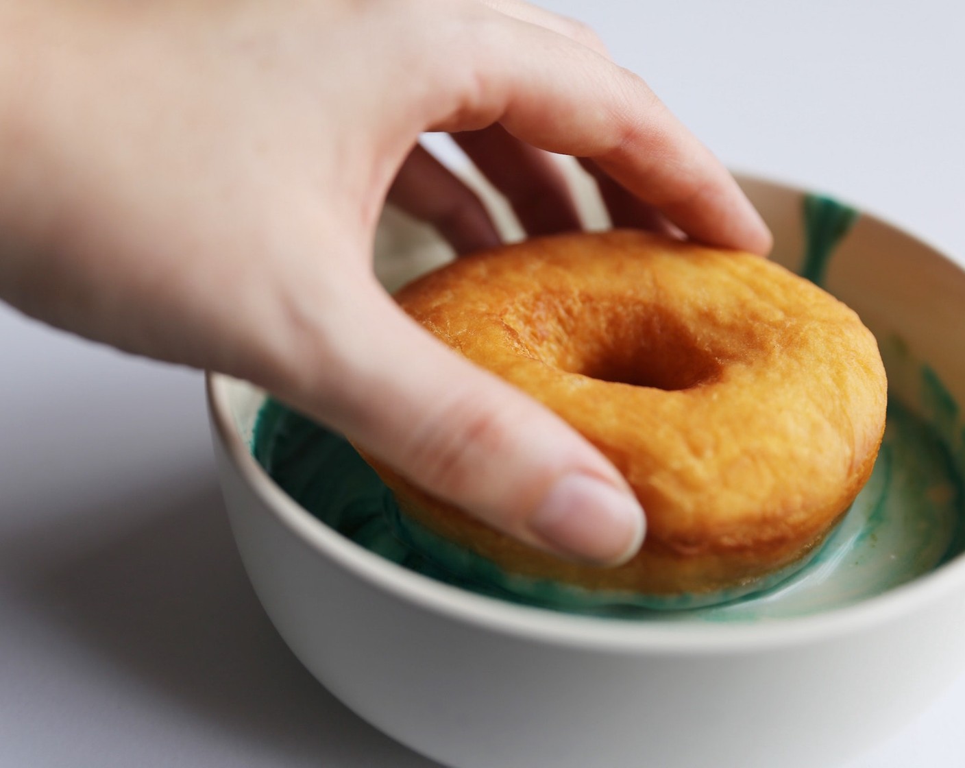 step 21 Begin dipping each doughnut into the glaze and gently swirl, twisting the doughnut out of the bowl and placing back on to the wire rack.