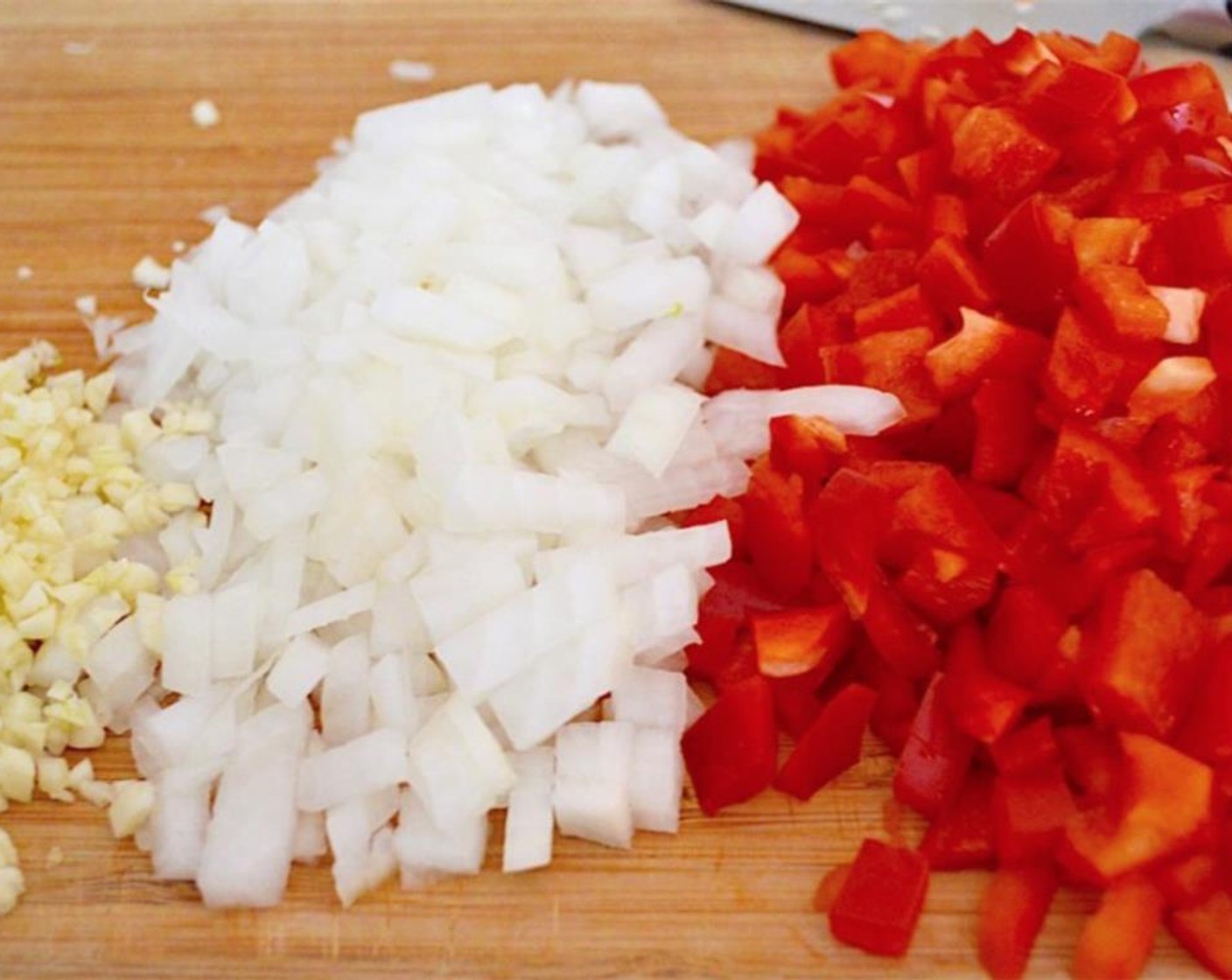 step 7 When all of the chicken is cooked and removed, add the Red Bell Peppers (2), Onion (1), and Garlic (4 cloves) into the pot.