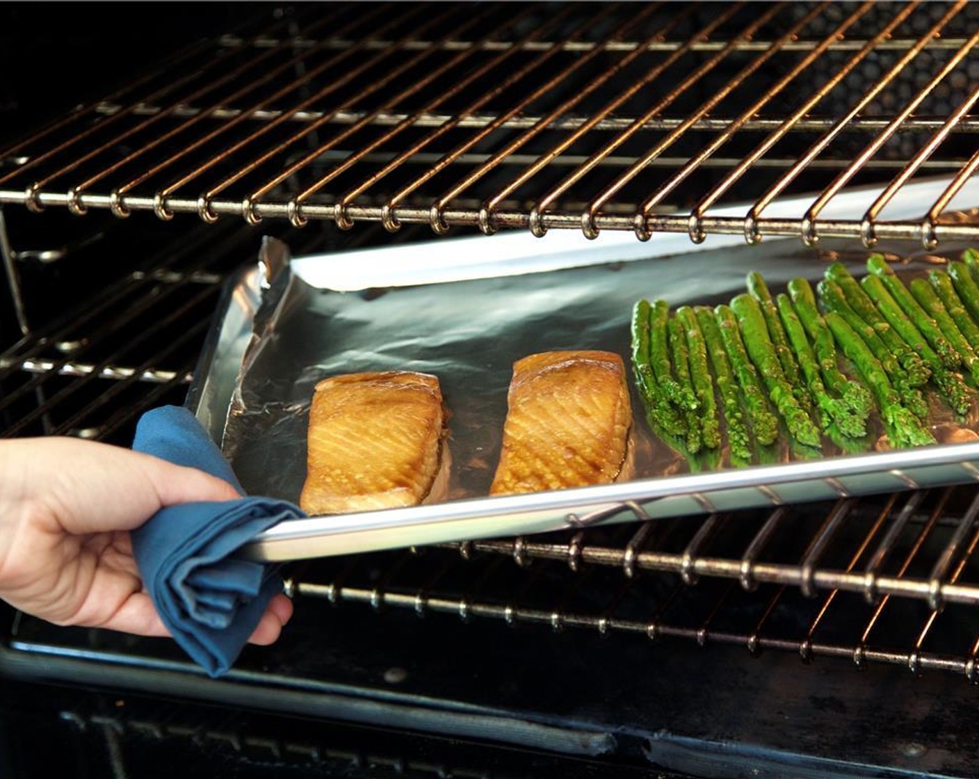 step 7 Remove the salmon from the marinade and place on the sheet pan next to the asparagus. You'll have some marinade remaining in the bag. Spoon it over the salmon fillets. Roast in the oven for nine minutes.