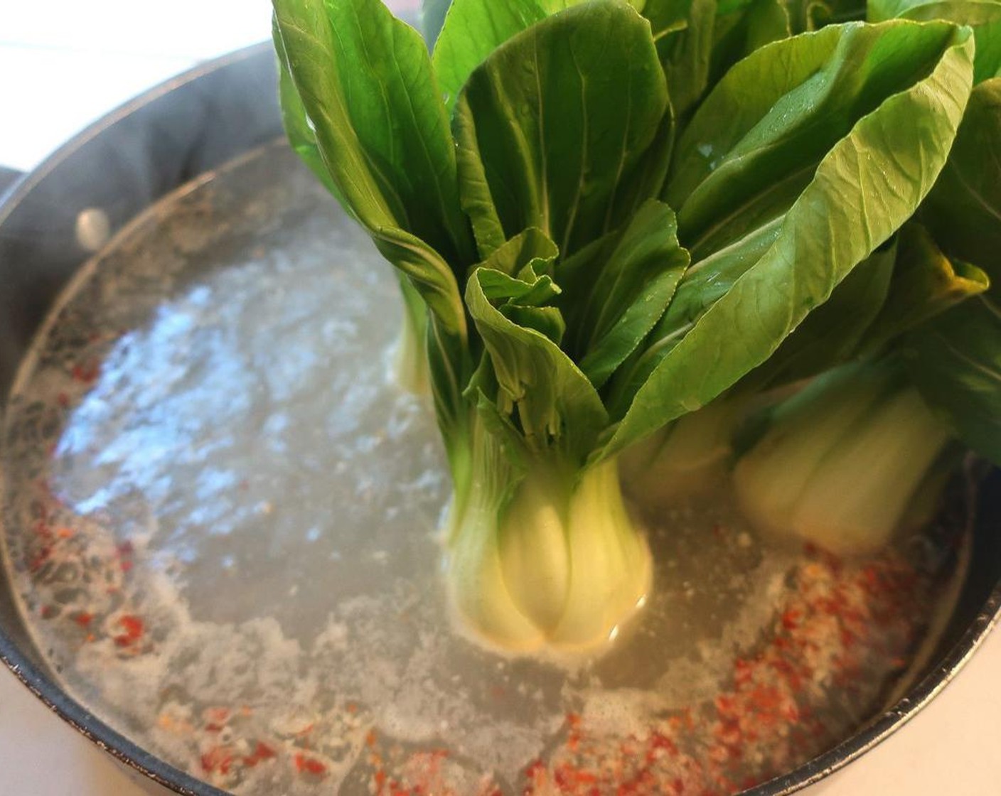 step 1 Cook the Baby Bok Choy (8) in salted water with Crushed Red Pepper Flakes (1 tsp). Submerge the stems first for 1 – 2 minutes, depending on the size, then turn on its side to simmer the leaves as well.