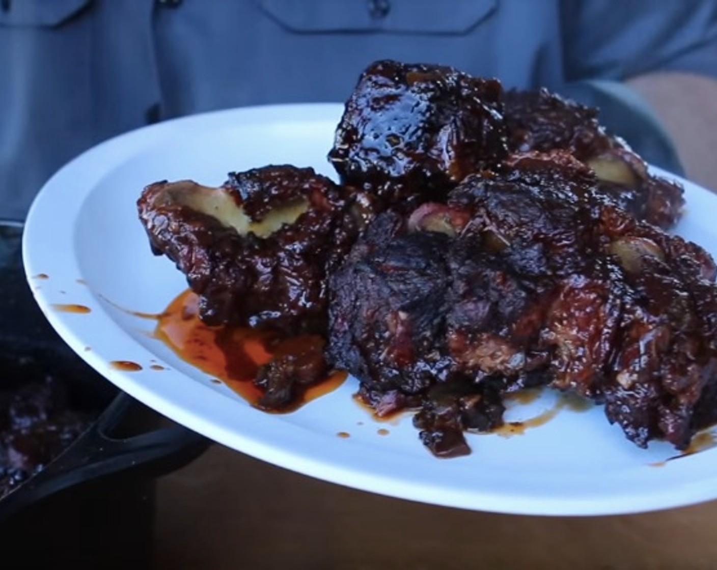 step 11 Remove iron pot from smoker and carefully transfer each oxtail to a large platter. Strain the braising liquid and skim fat from top.