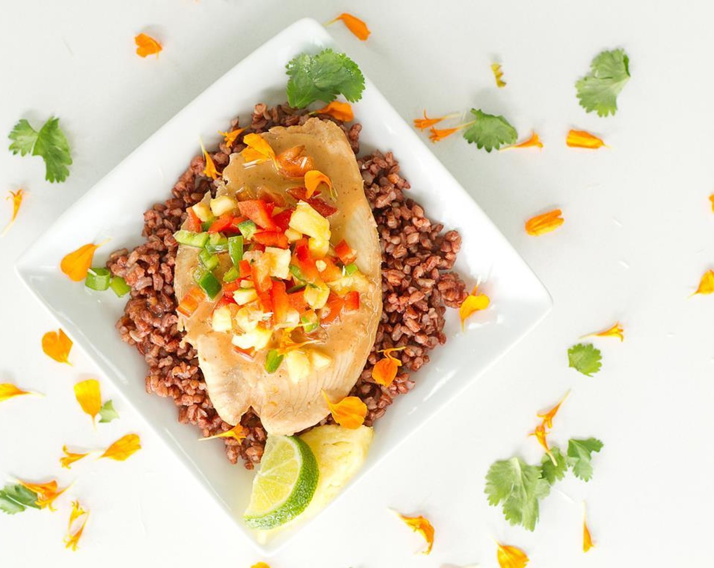 step 12 Once the fish is cooked, unwrap and serve it on plate with rice. Drizzle marinade over fish and top with fruit salsa.