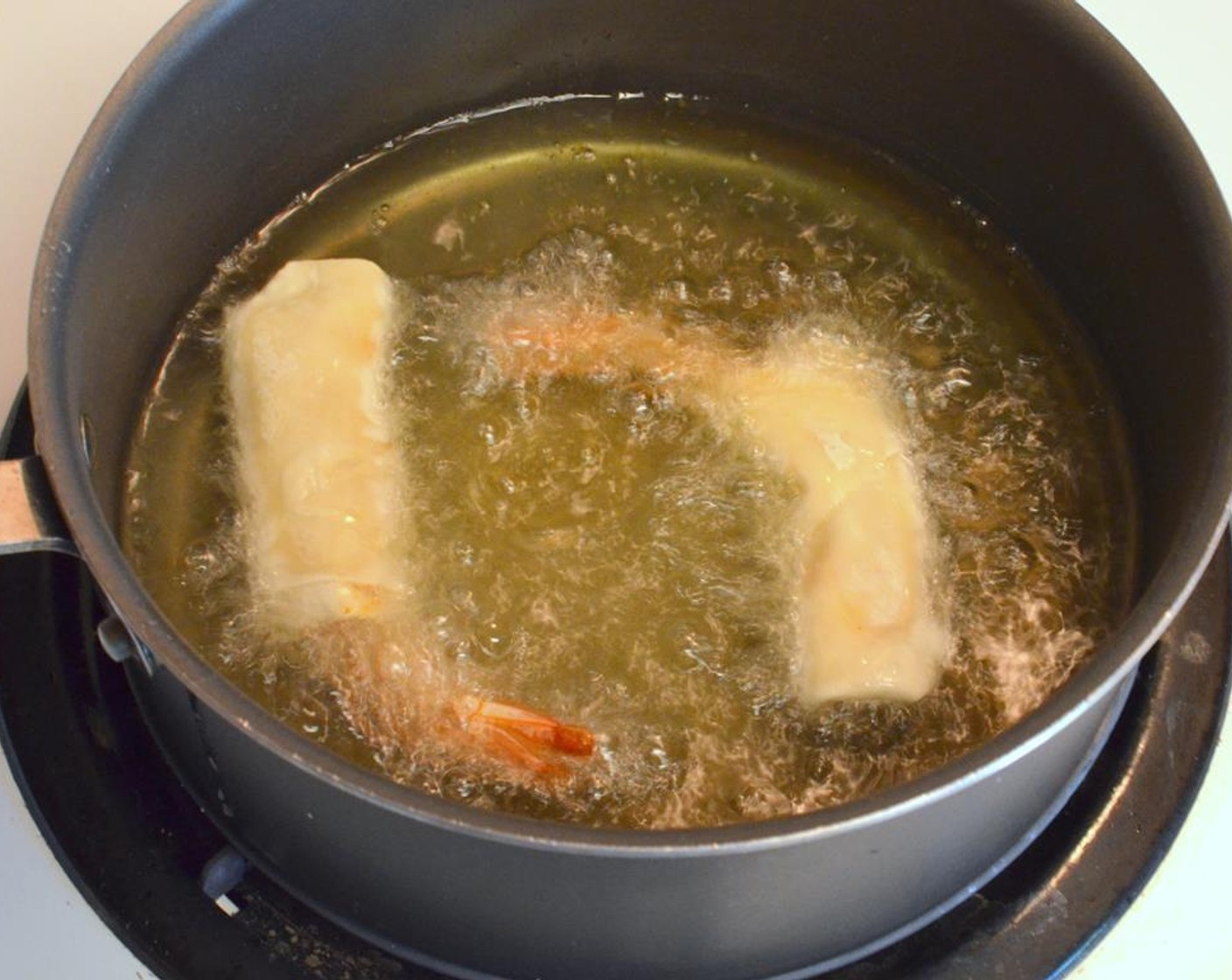 step 13 In a pan, add about an inch or so of Vegetable Oil (as needed) to fry the shrimp. Heat the oil through on medium-high. Fry the shrimp in small batches and cook them for 2-3 minutes on each side till golden brown.