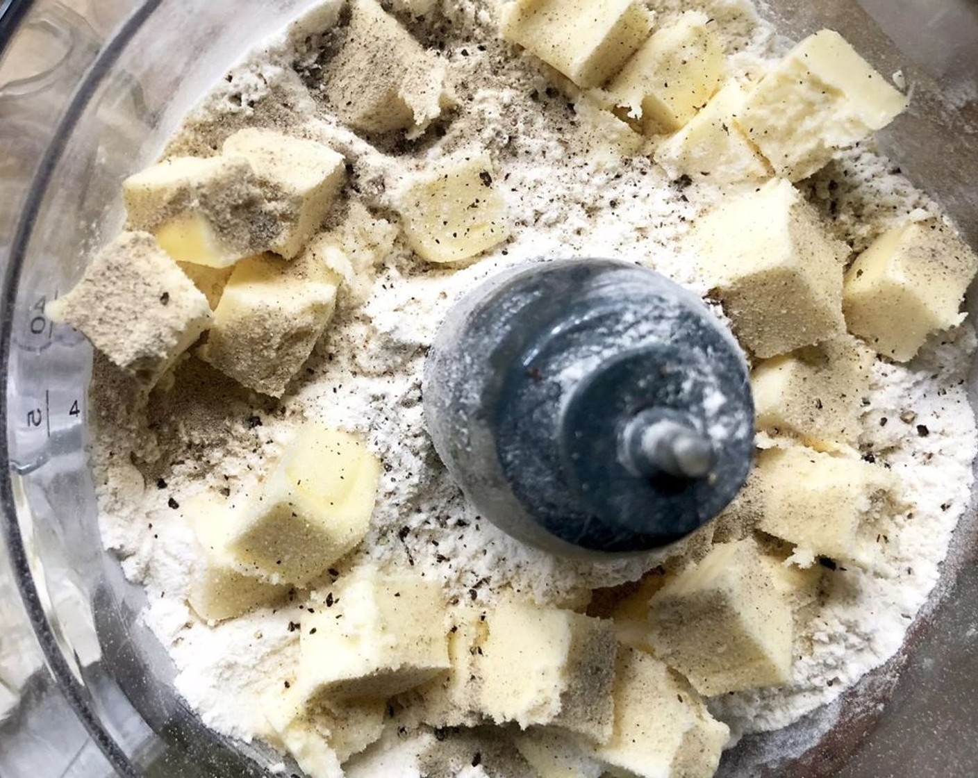 step 1 In the bowl of a food processor, add the All-Purpose Flour (2 1/4 cups), Unsalted Butter (1/2 cup), Salt (1/4 tsp), and Freshly Ground Black Pepper (1/4 tsp). Give it a few quick pulses until the mixture resembles pea-size crumbs.