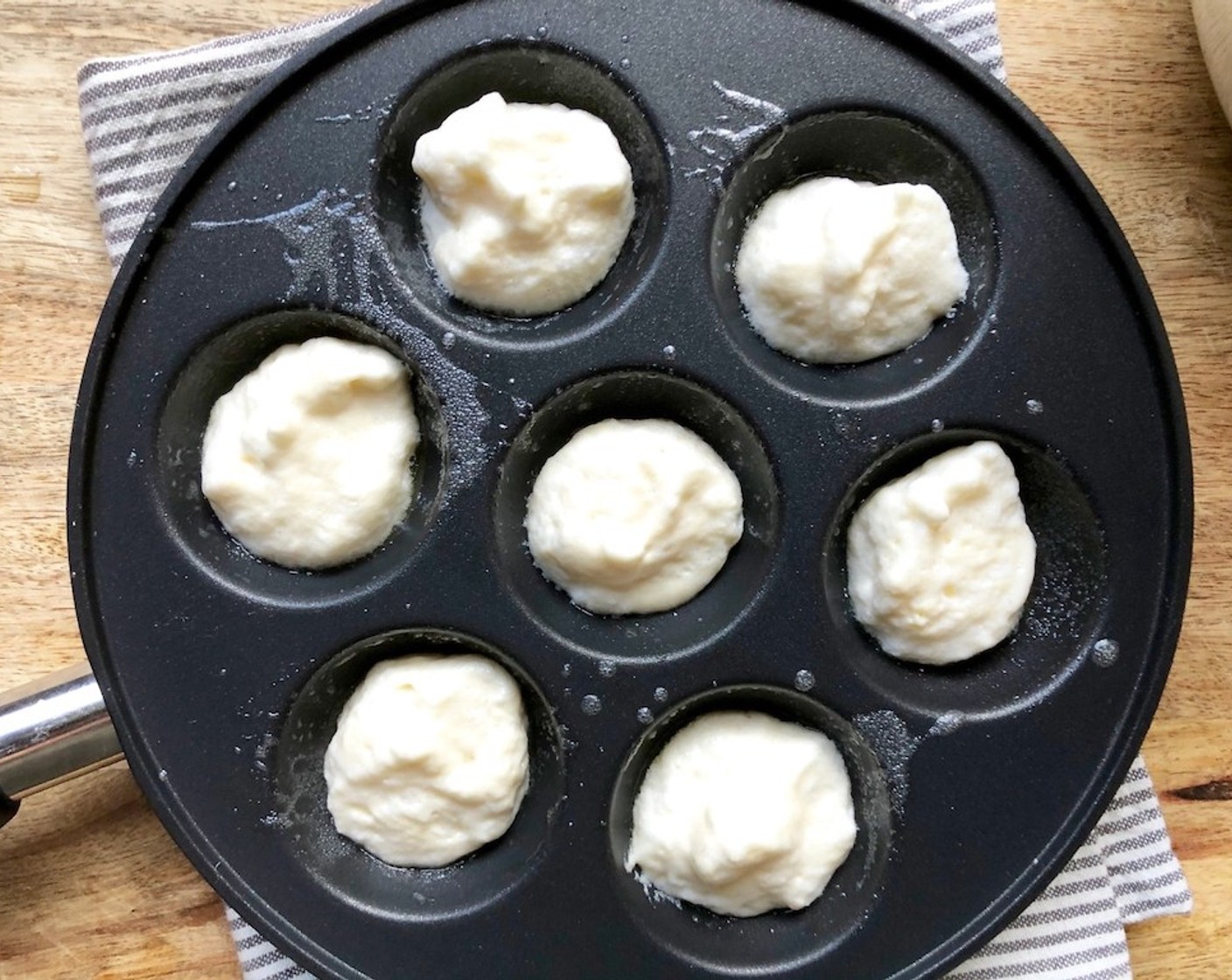 step 7 Make the Ebelskiver. Brush the wells of a filled-pancake pan with some Unsalted Butter (3 Tbsp). Heat over low-medium heat until the butter bubbles. Pour 1 Tbsp of the batter into each well and cook for 2 minutes.