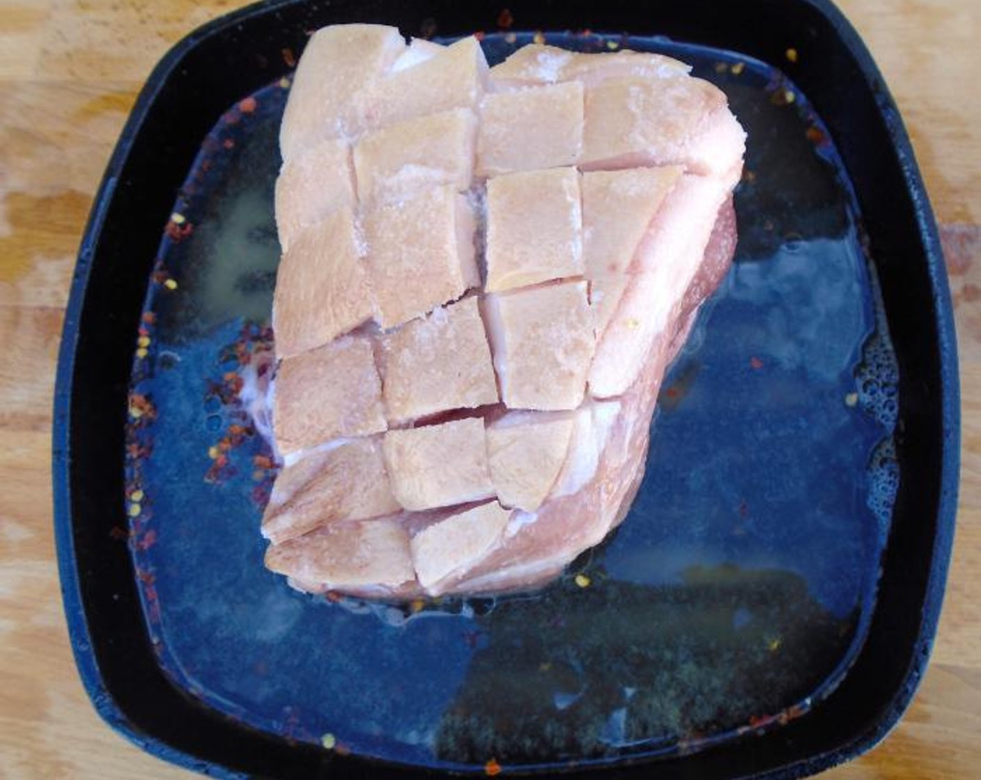 step 2 Score the skin of the Pork Shoulder (1/2) into 1-inch squares, seasoning with Kosher Salt (to taste), Cayenne Pepper (to taste) and Granulated Garlic (to taste).