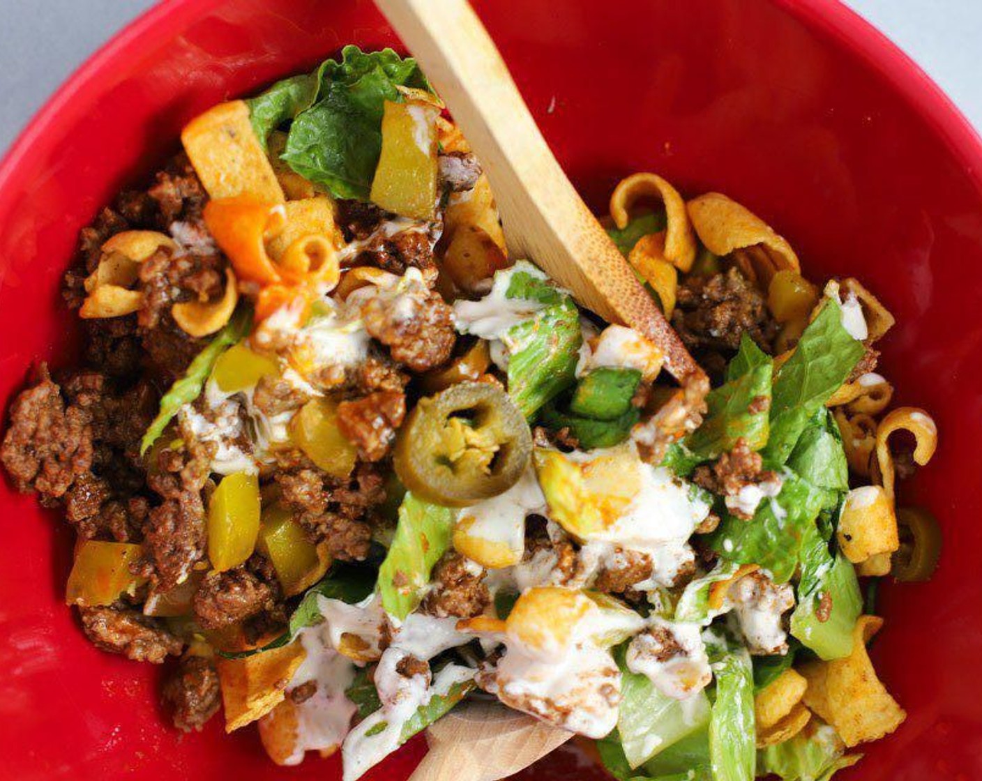 step 3 Mix Romaine Lettuce (4 cups), Corn Chips (2 cups), Pickles (3/4 cup), Pickled Jalapeño Pepper (1/2 cup), French Salad Dressing (1/4 cup), Ranch Dressing (2 Tbsp) and cooked beef in a large bowl. Use a large serving spoon or tongues to plate on dishes.